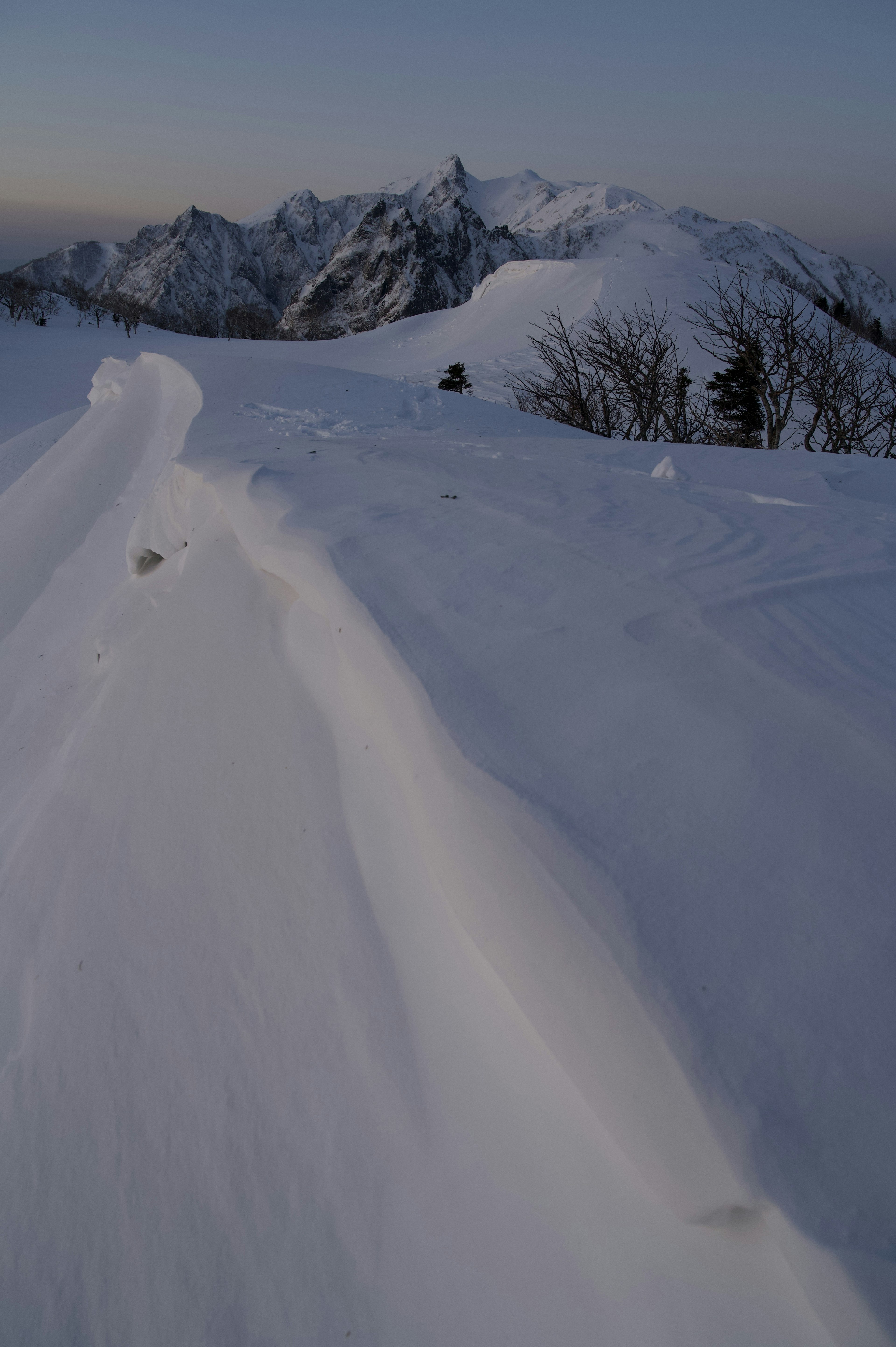 Snow-covered mountain landscape with smooth snow drifts