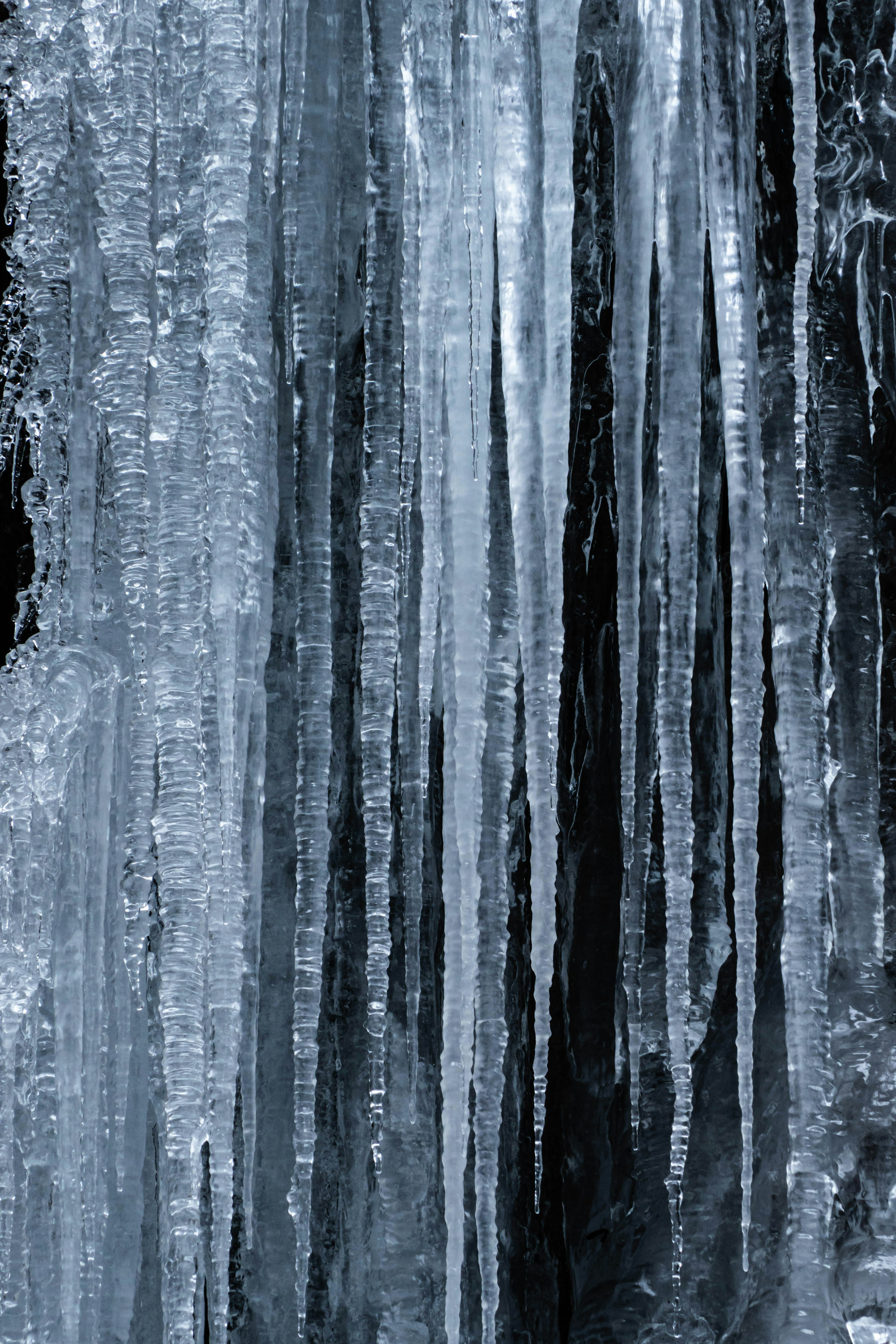 Close-up dari icicles yang menggantung dari permukaan beku