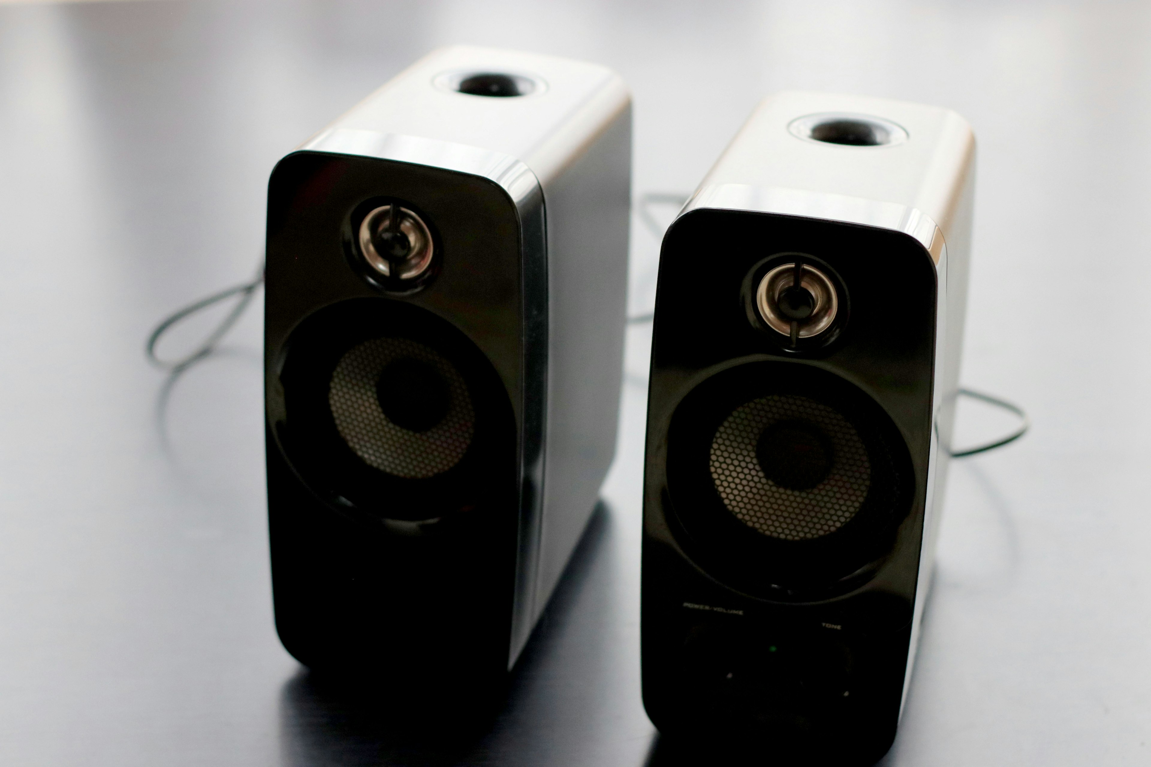 Pair of black and silver speakers on a dark surface