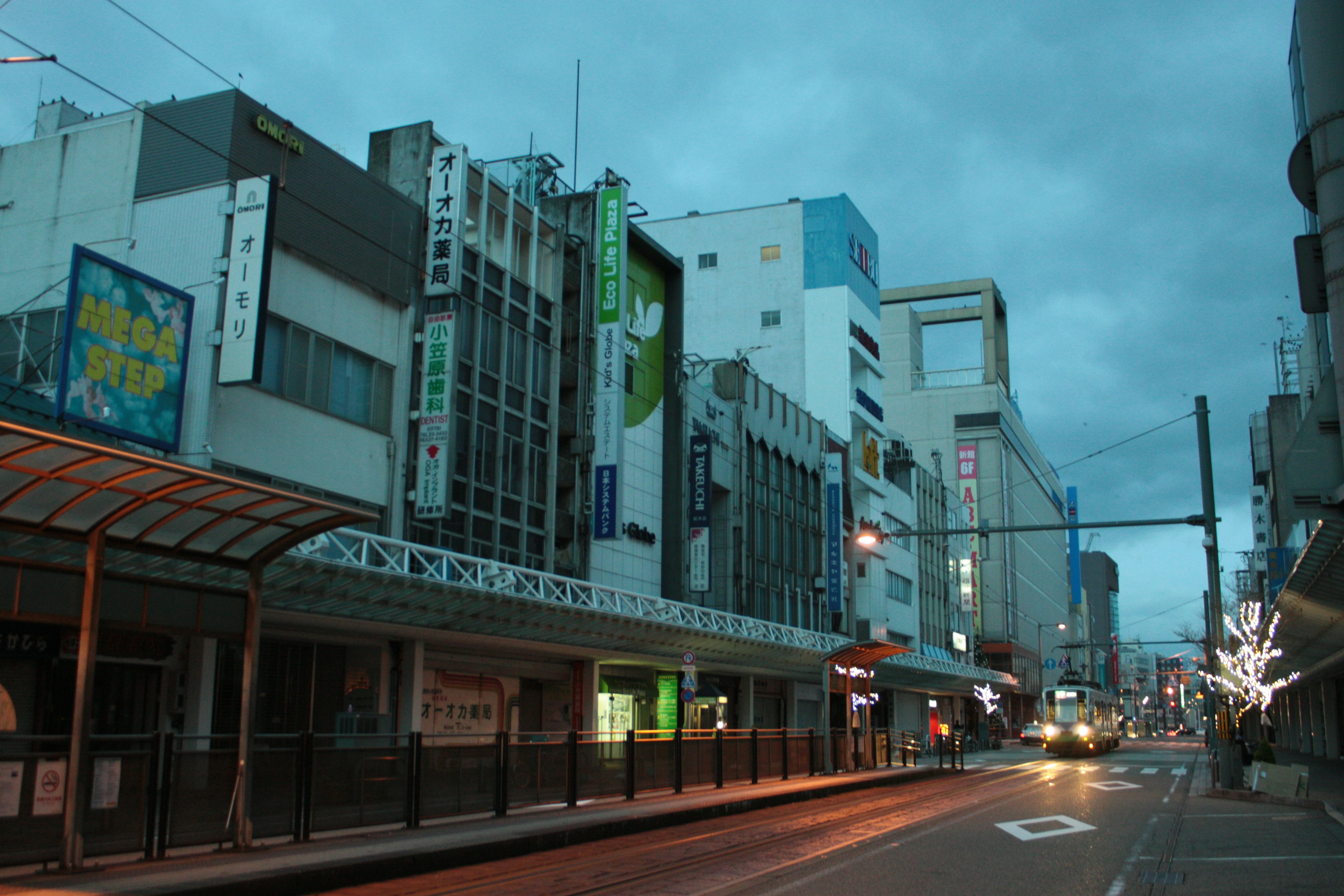 Escena de calle tranquila con edificios comerciales al anochecer