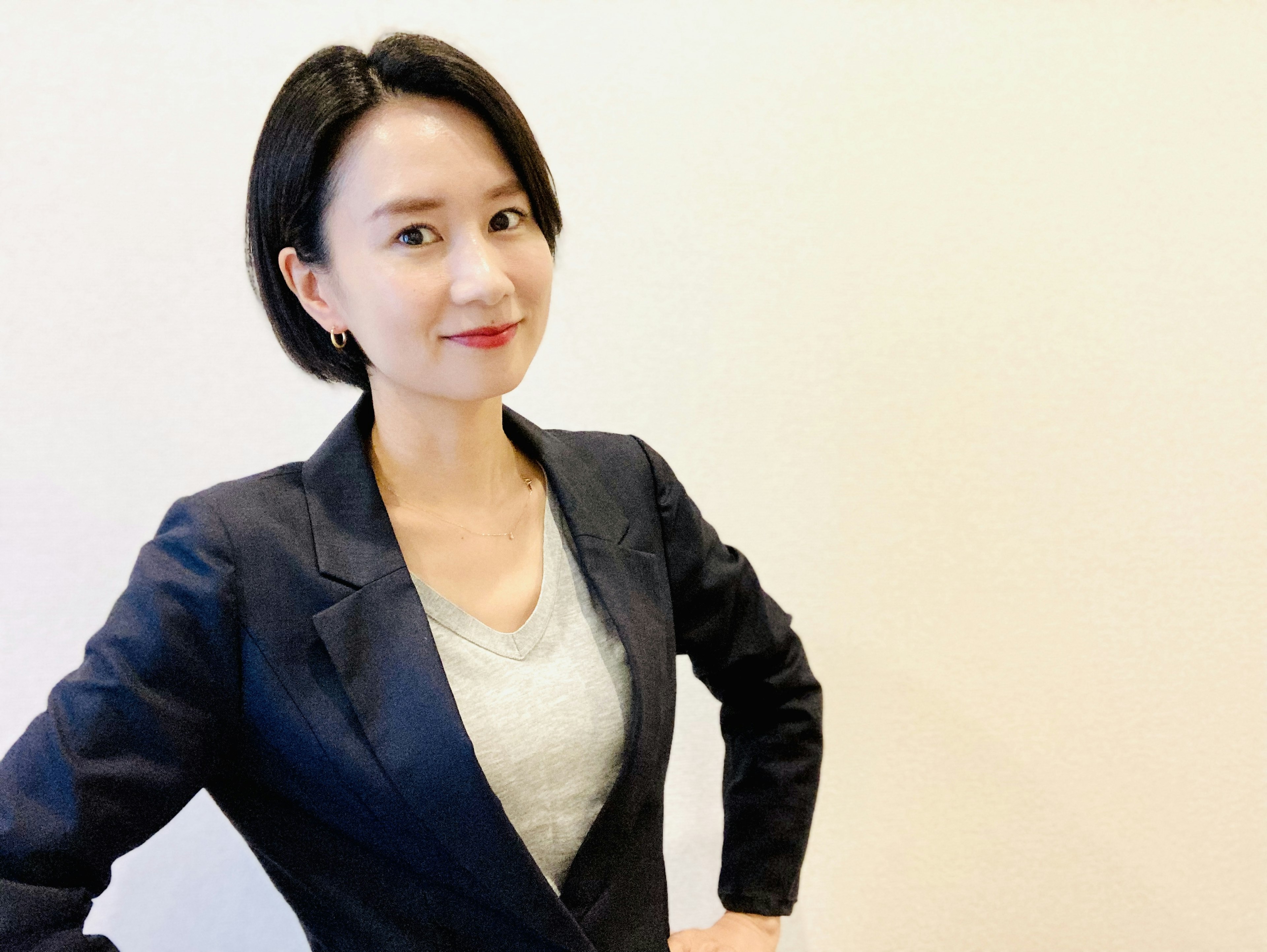 A woman in a business suit posing confidently with a smile