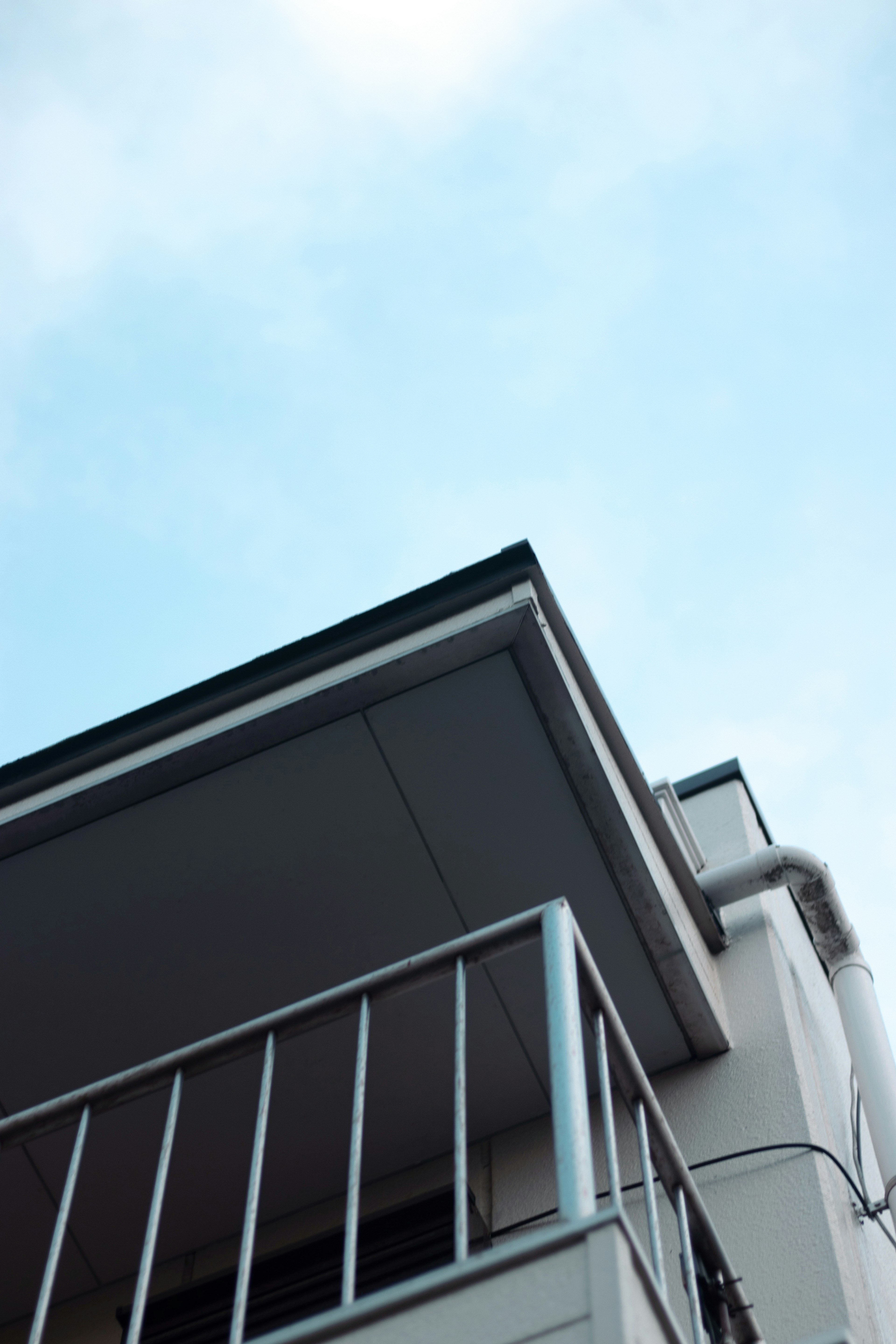 Vue en angle du balcon et du toit d'un bâtiment contre un ciel bleu