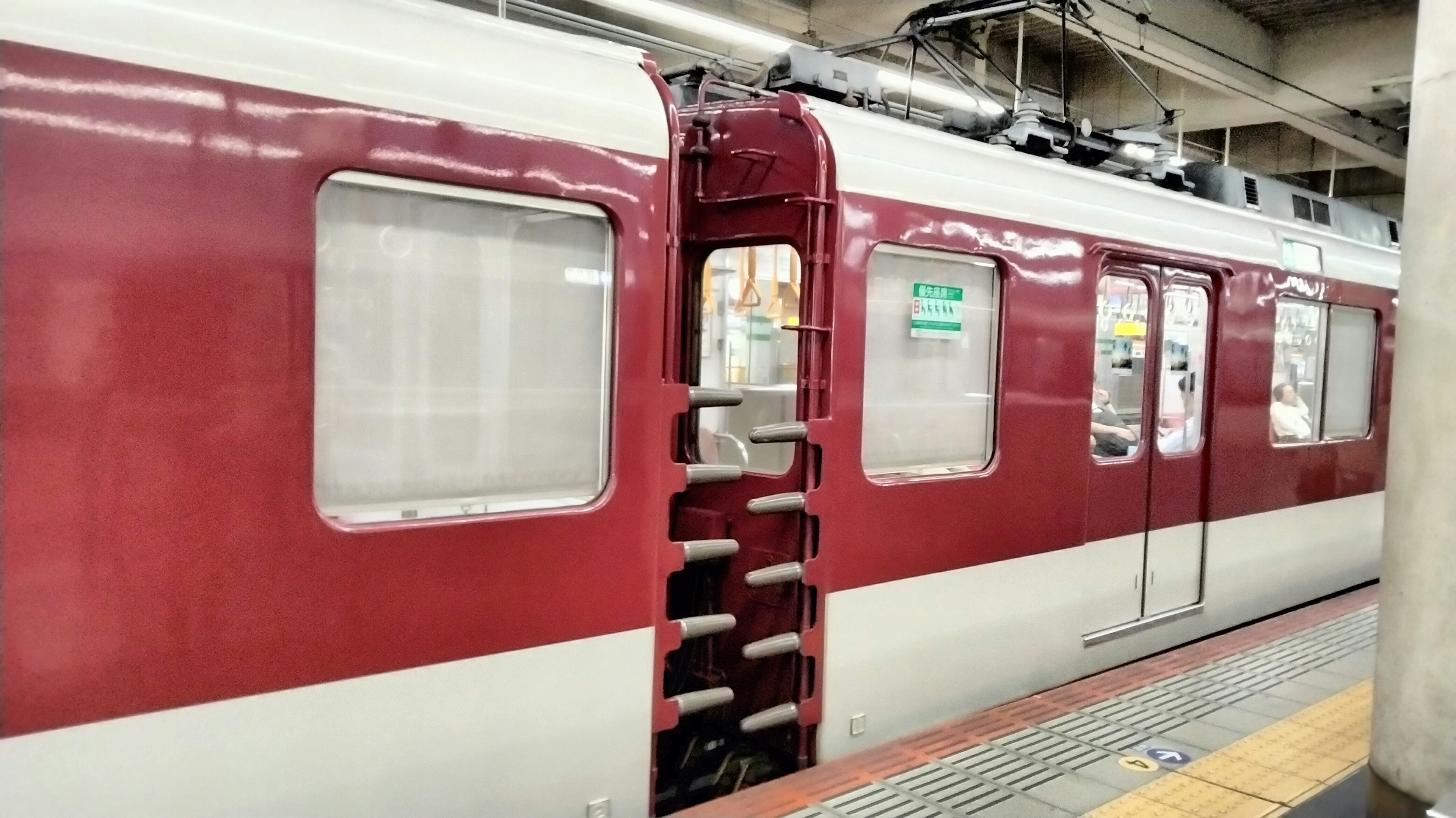 赤い電車の扉が開いている駅の風景