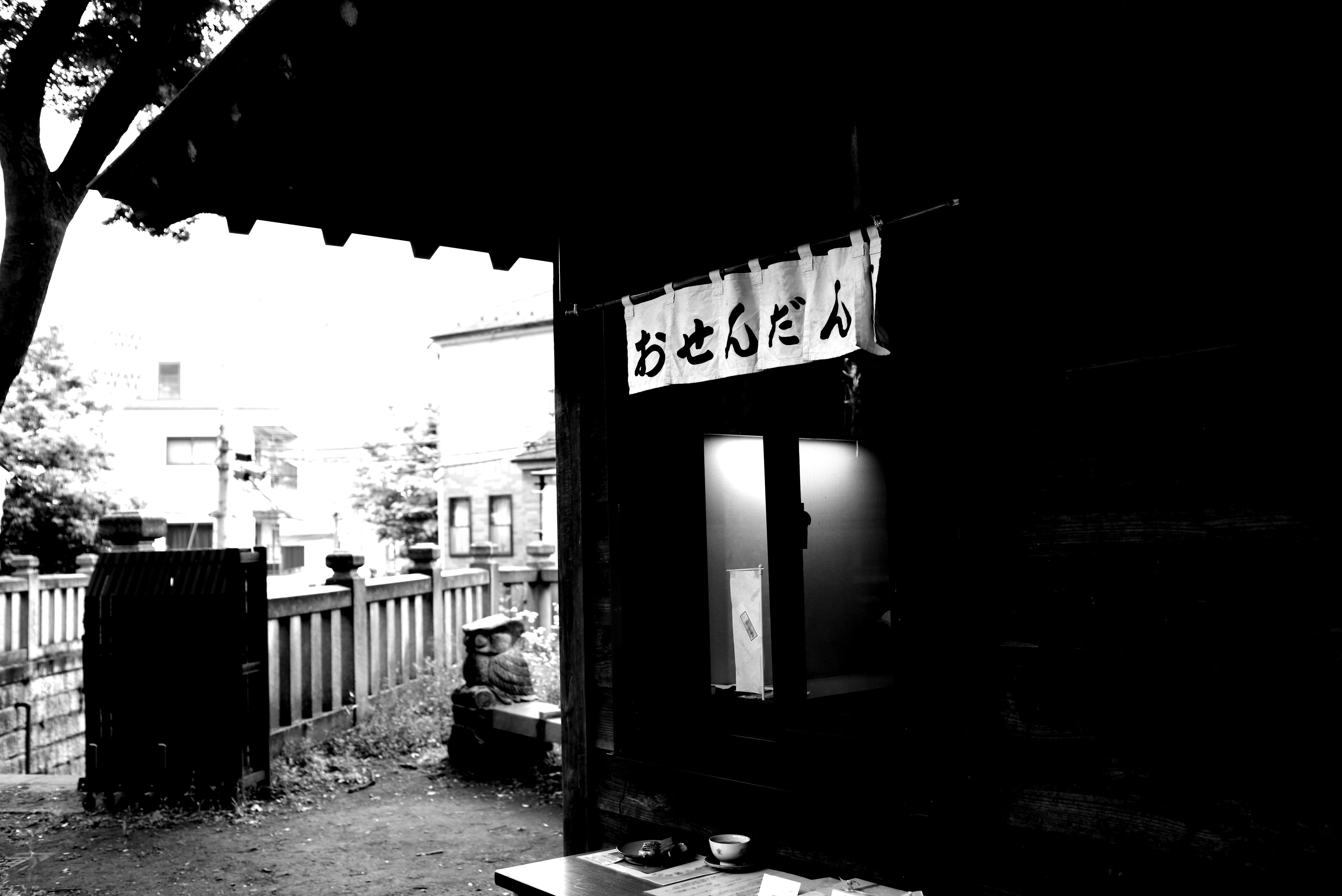 Entrada de un edificio antiguo en blanco y negro con un letrero japonés