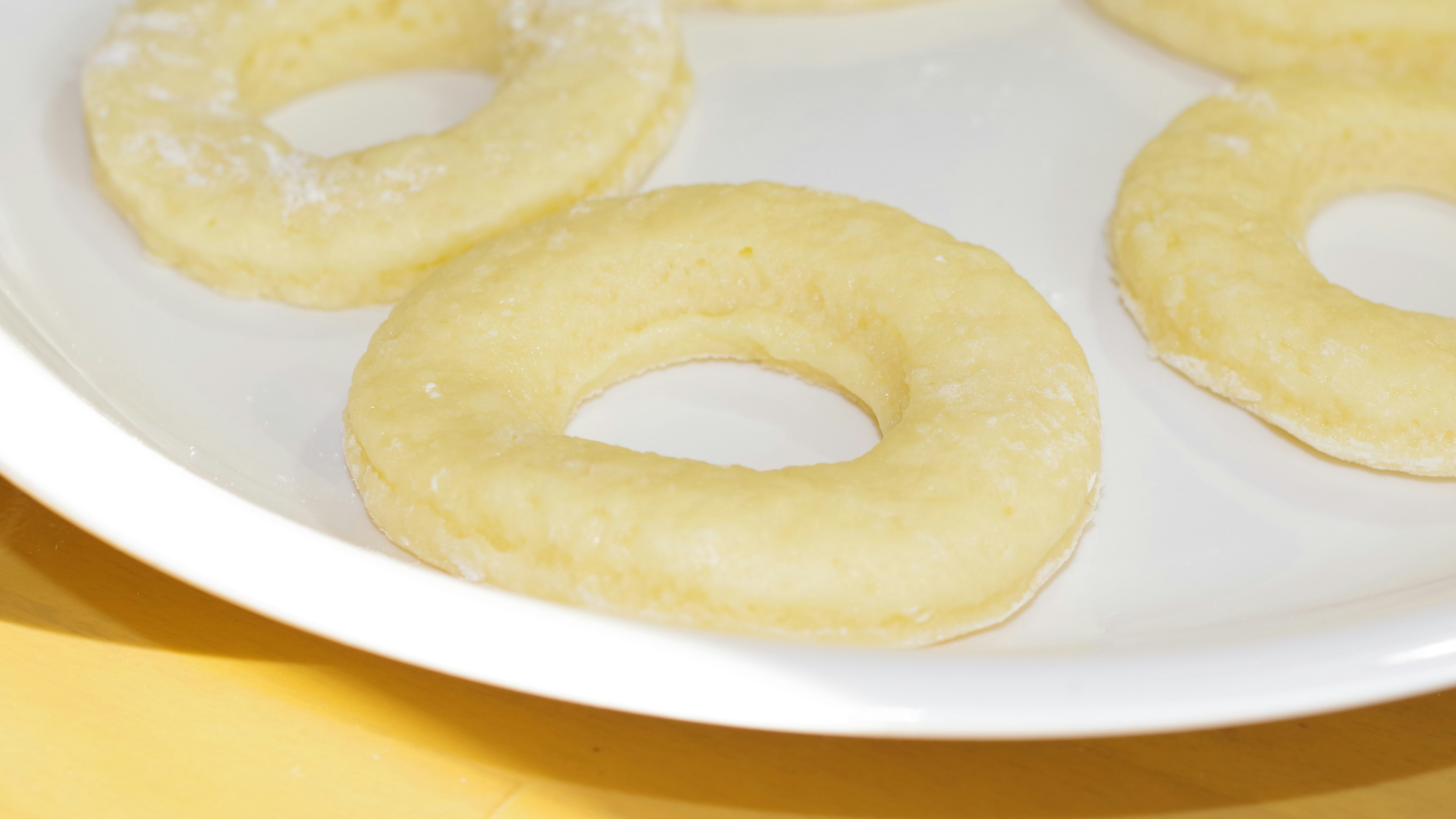 Impasto di ciambelle crudo disposto su un piatto bianco