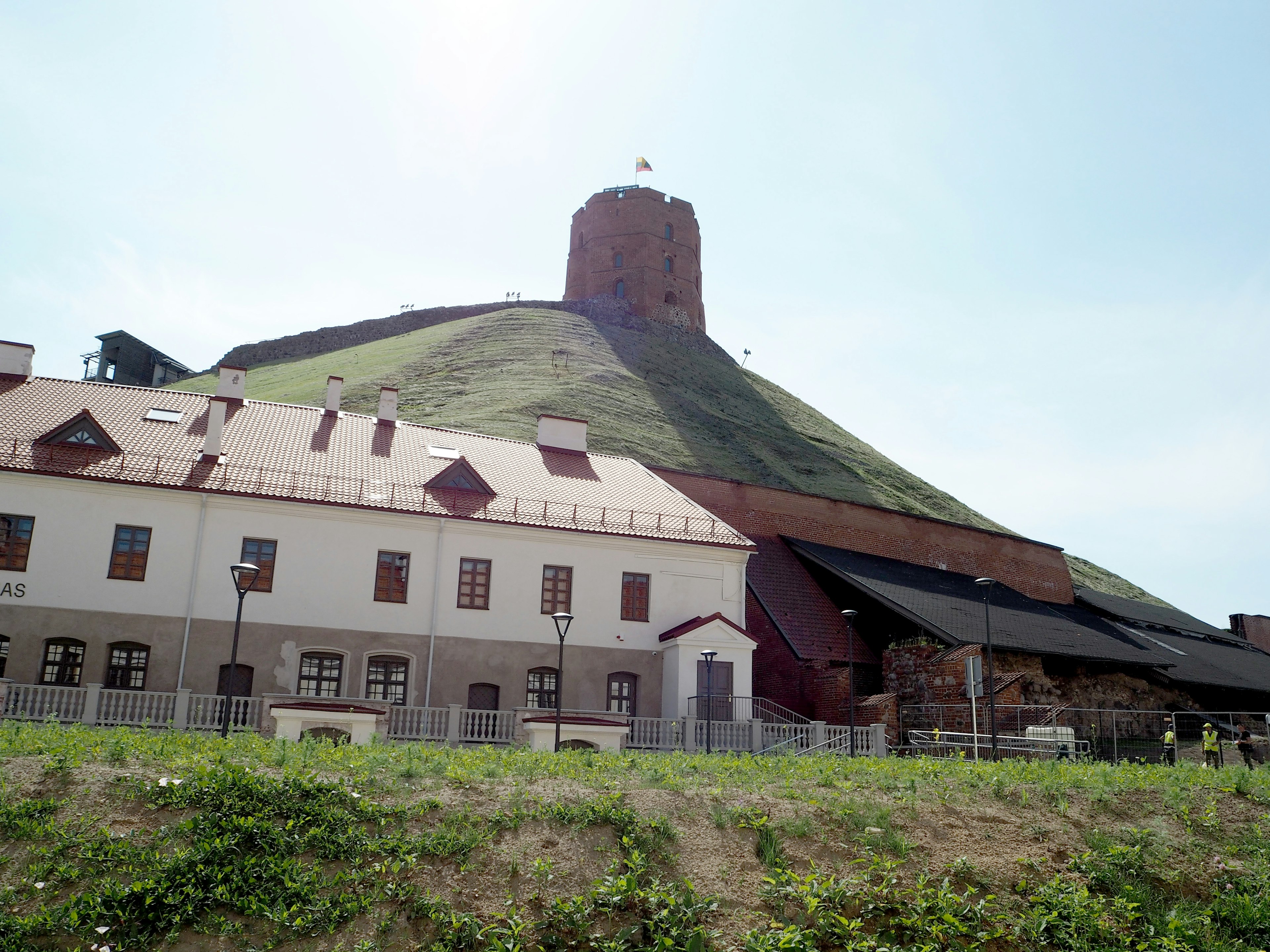 A tower atop a hill with surrounding buildings in the foreground