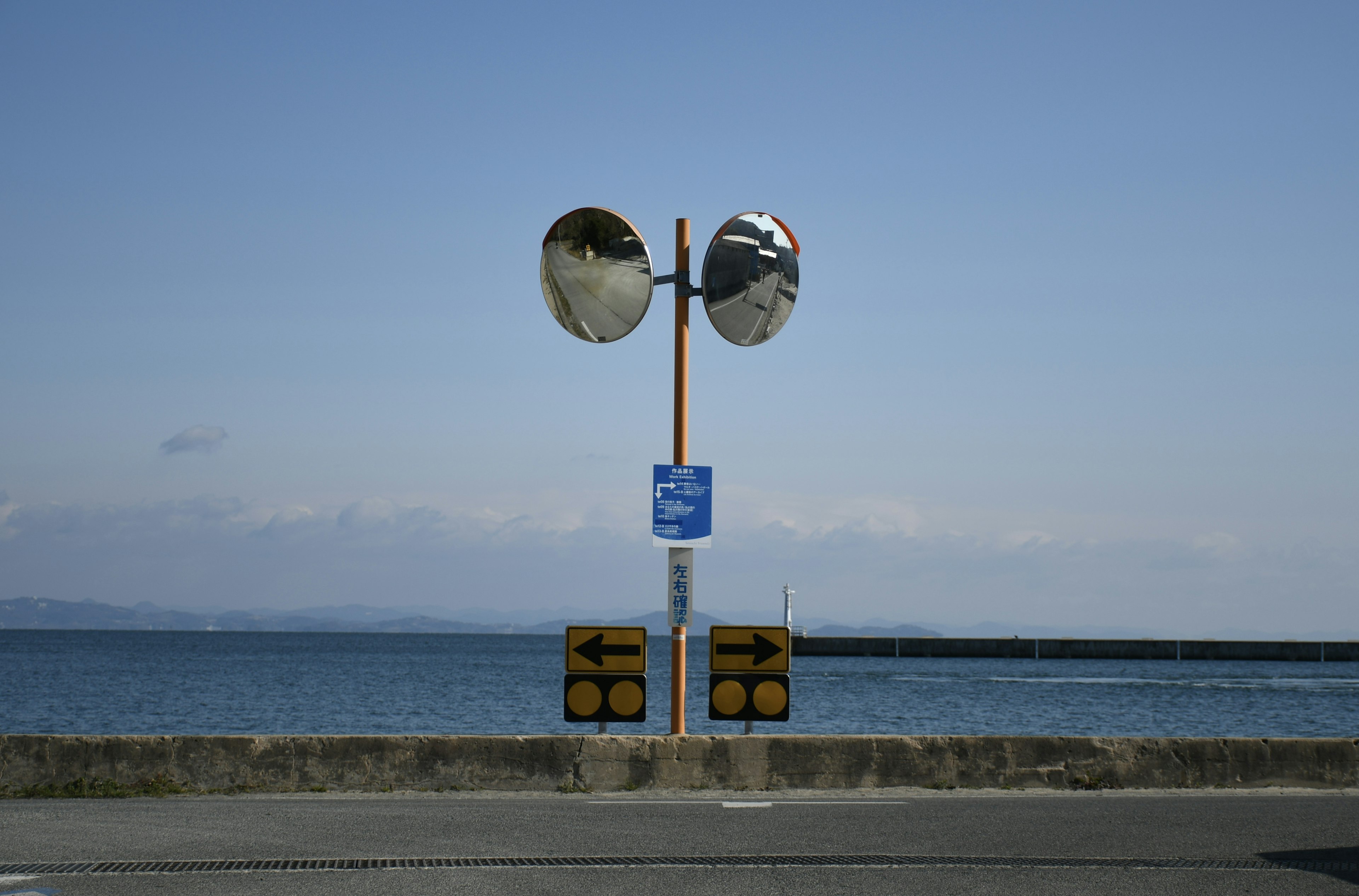 海岸沿いの交通ミラーと信号機の画像