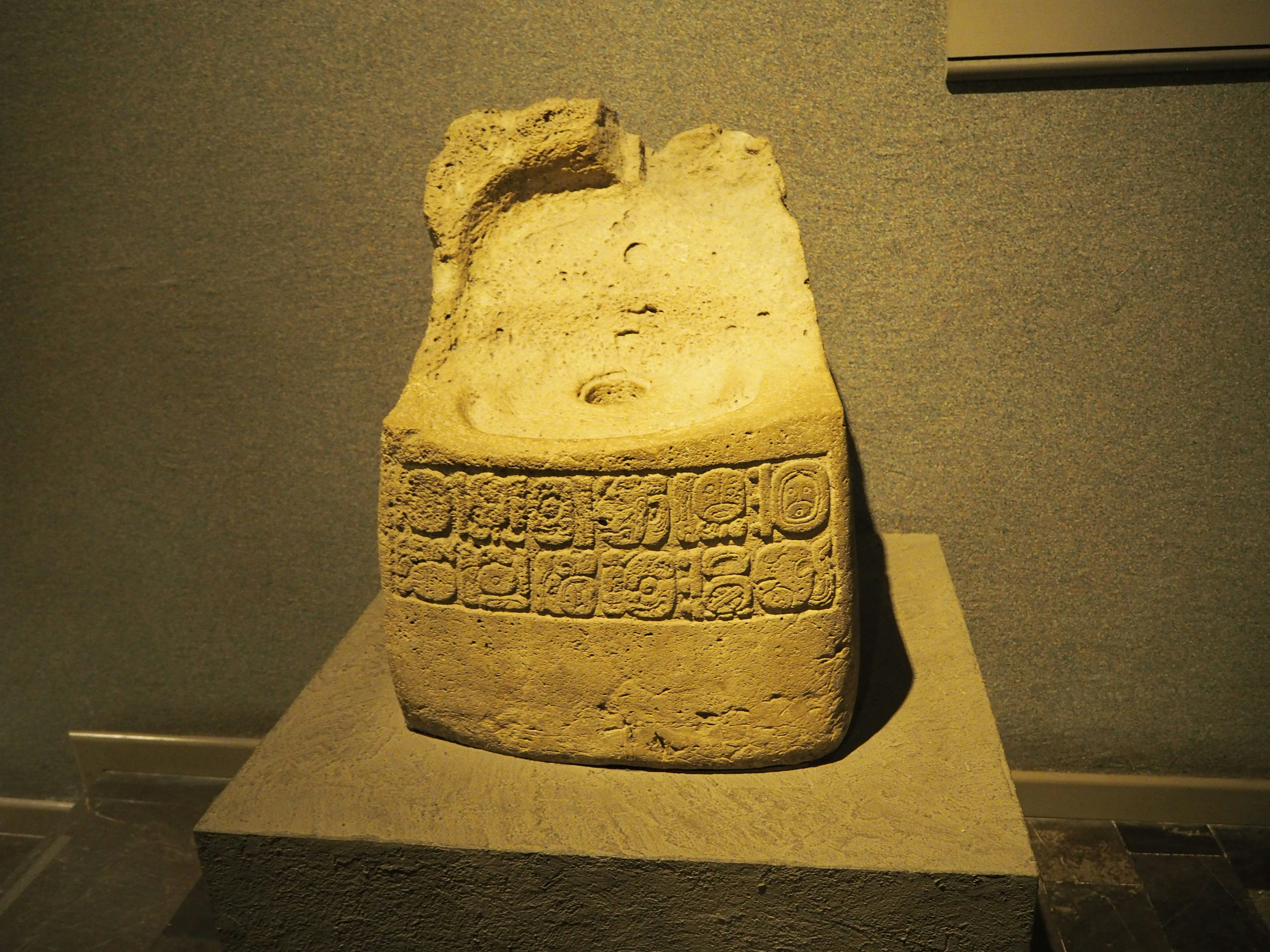 Fragment of an ancient stone tablet with carved inscriptions