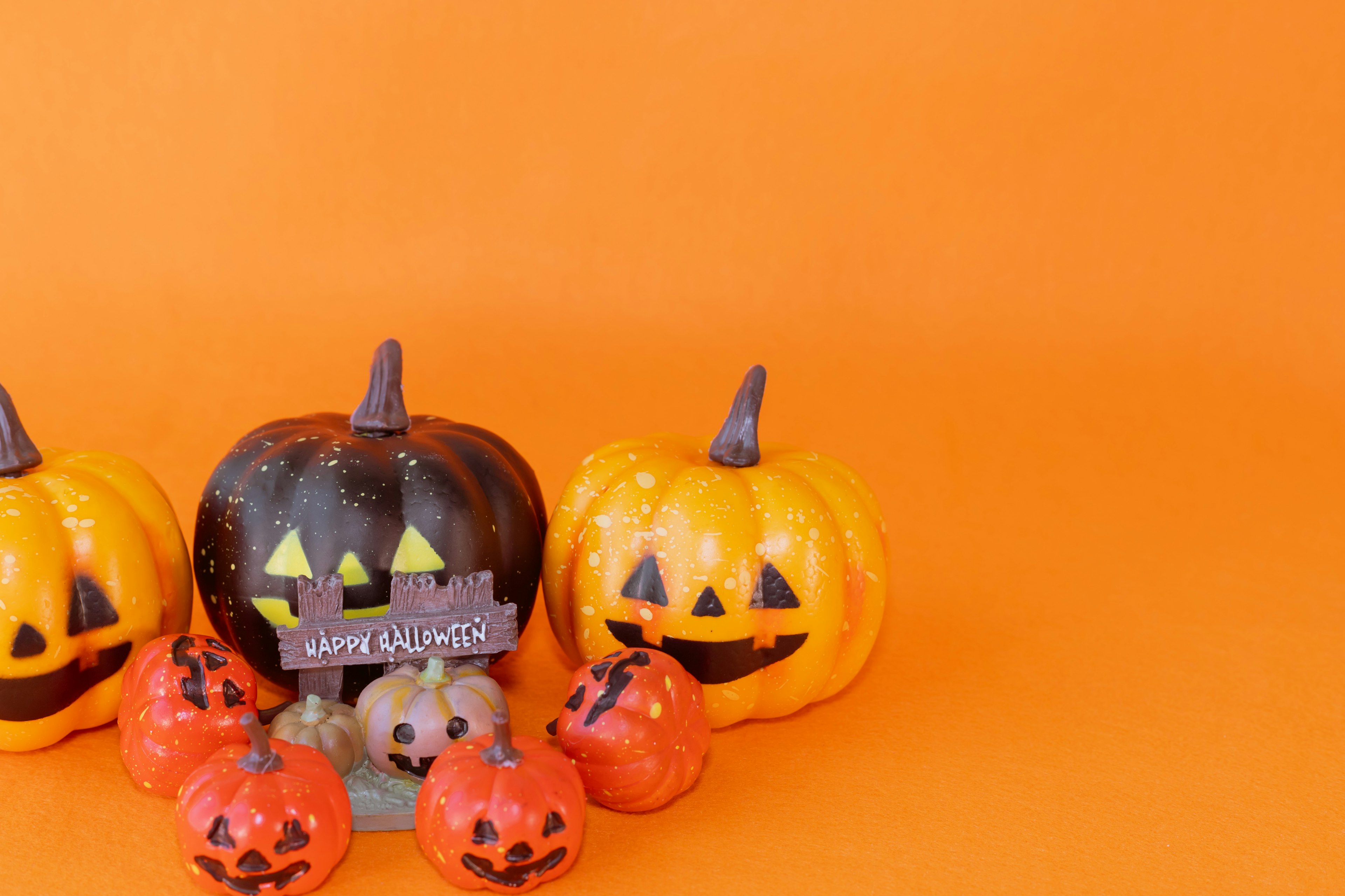 Zucche di Halloween su sfondo arancione con un tema nero e arancione