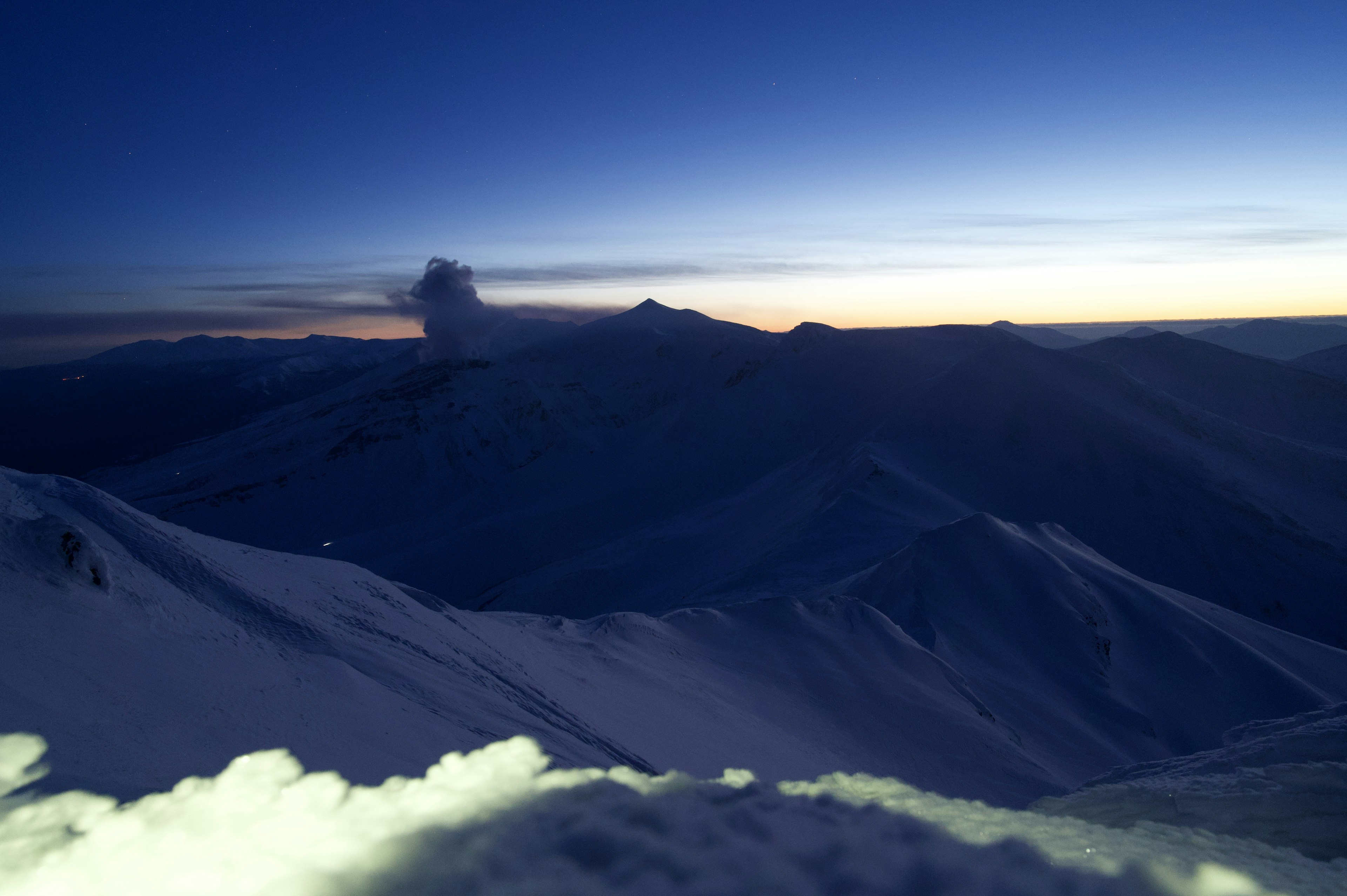 Montagnes enneigées sous un ciel crépusculaire