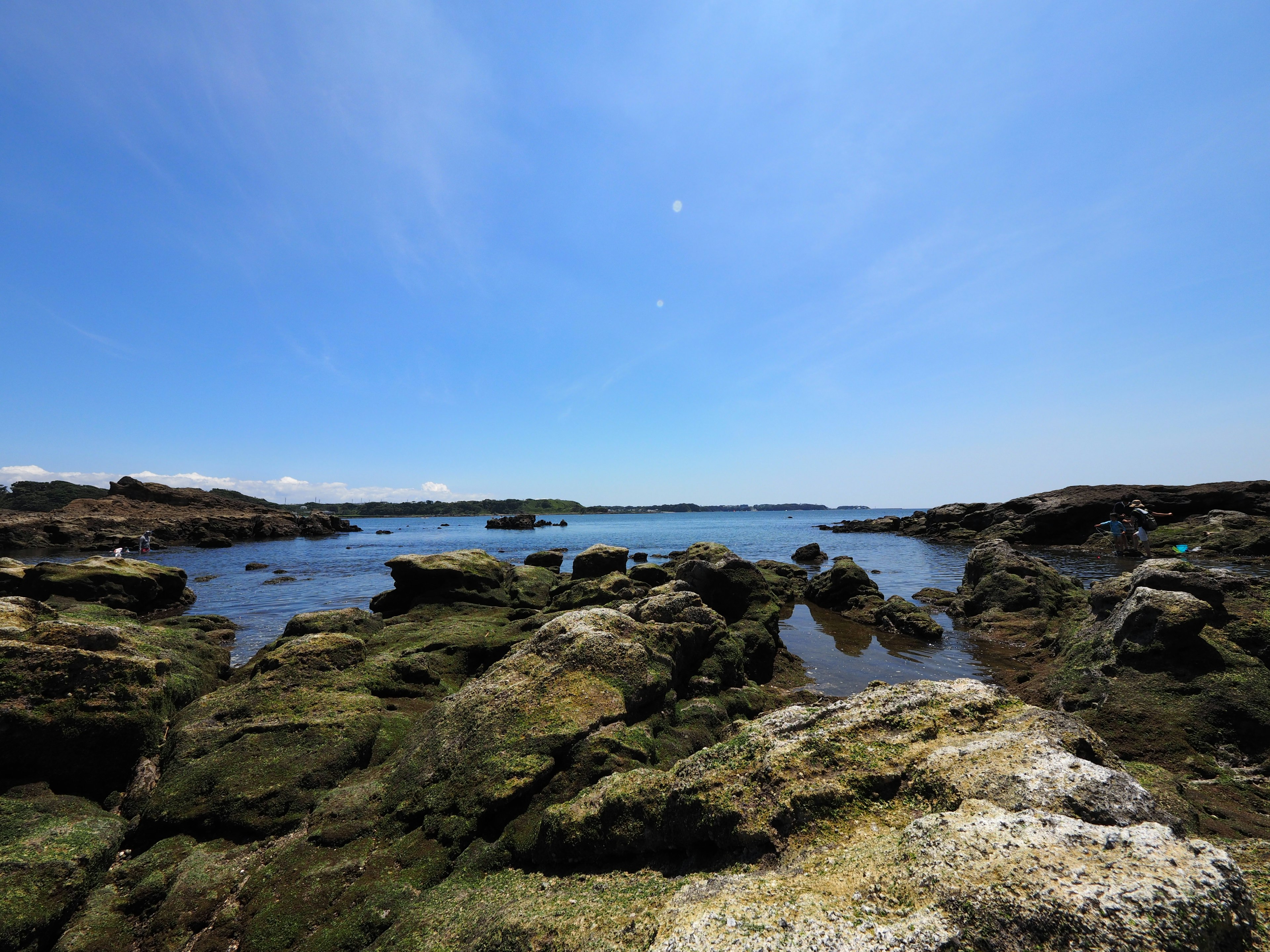 Coastal landscape with blue sky and rocky shoreline