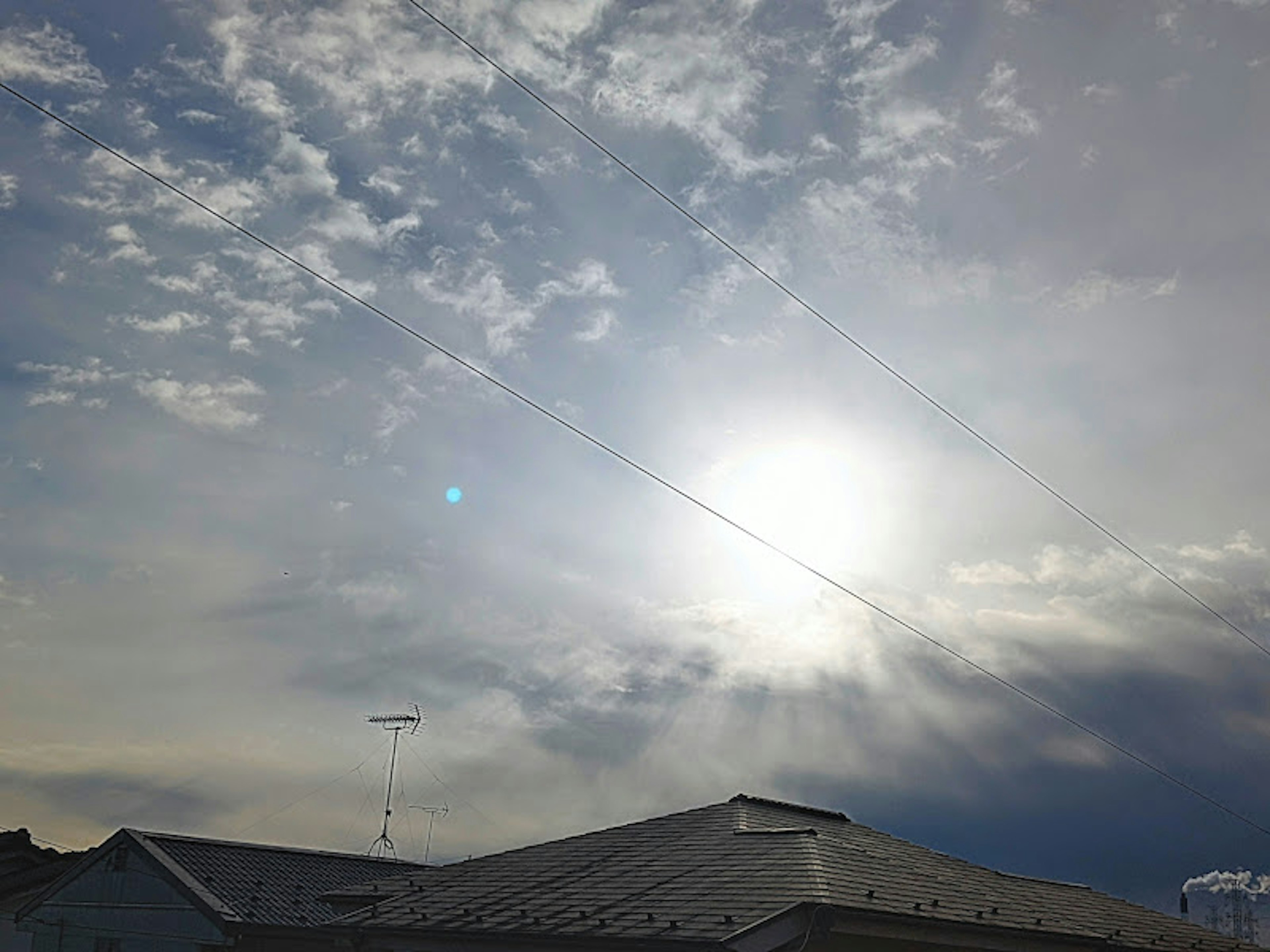 青空と雲に囲まれた明るい太陽の画像