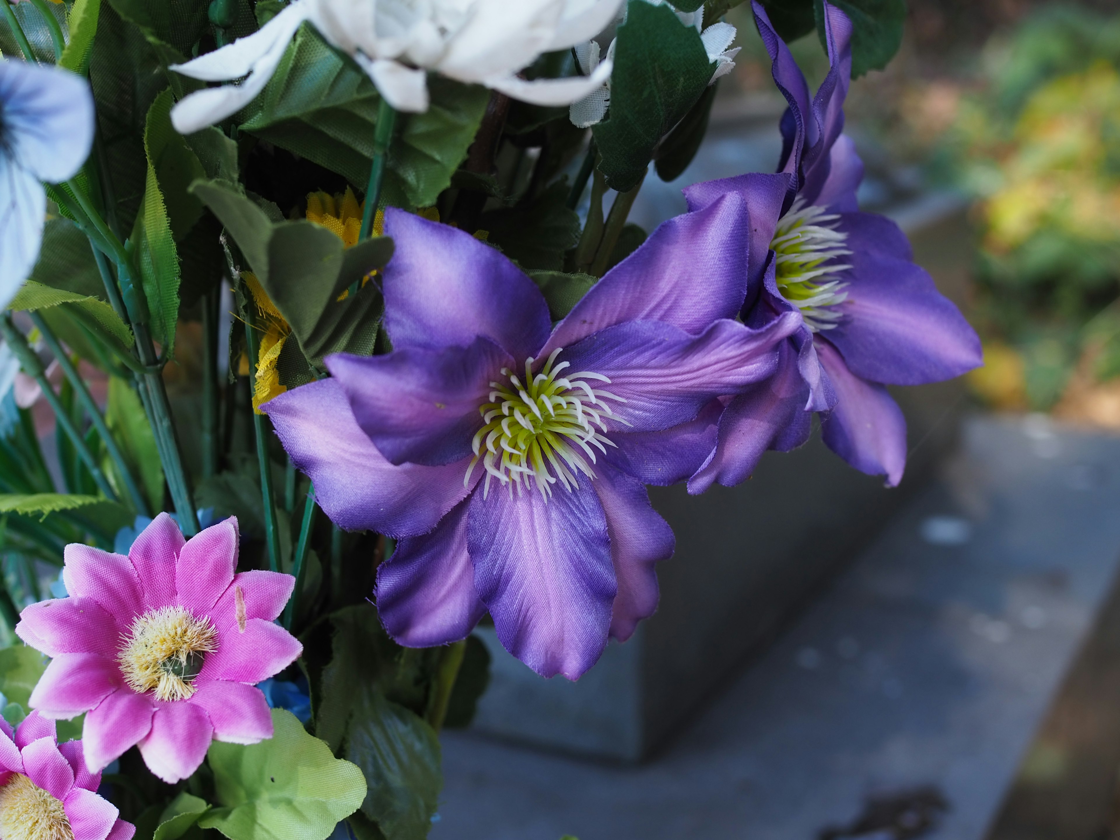 Purple and pink artificial flowers in a bouquet