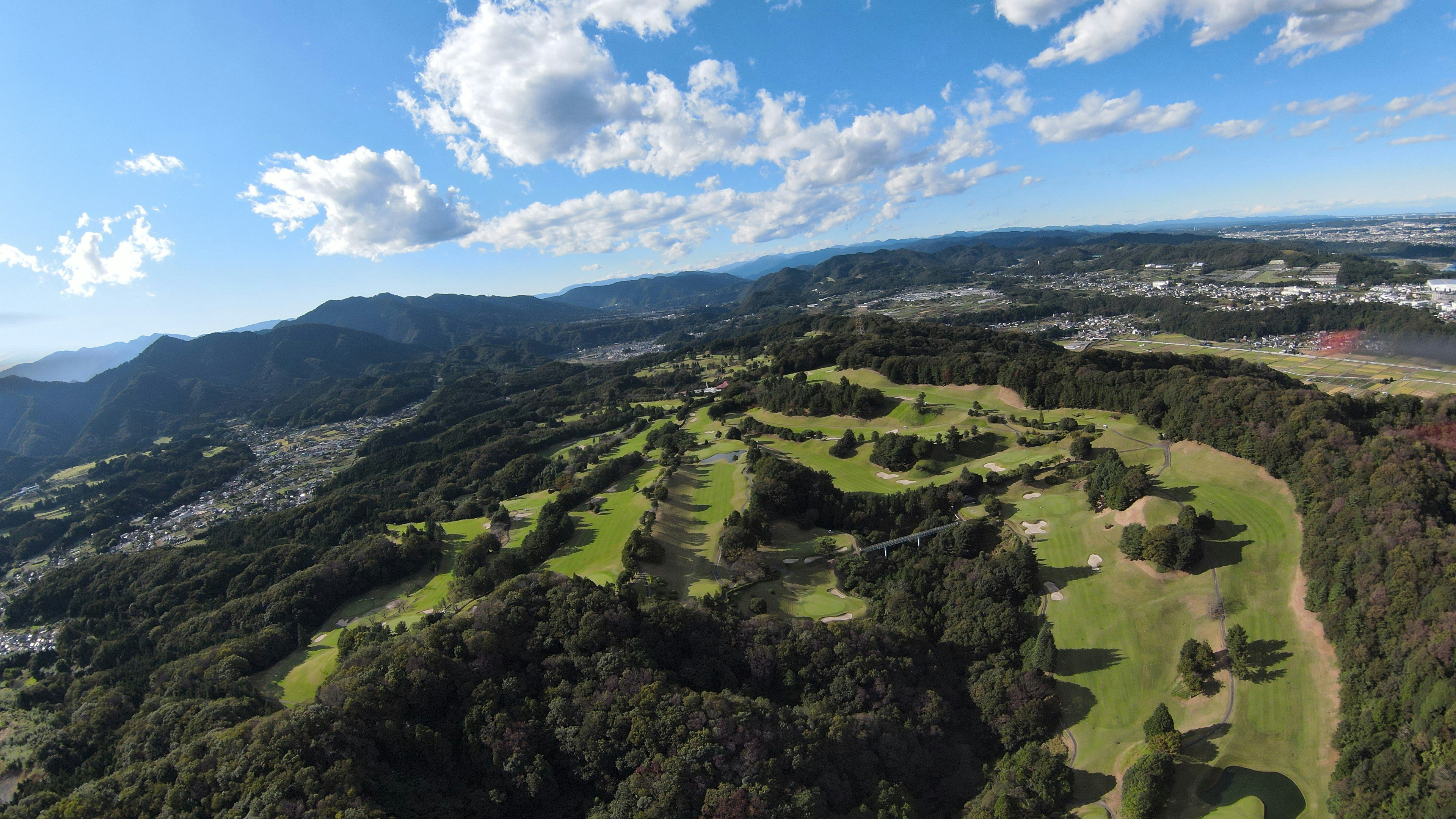 Pemandangan udara lapangan golf hijau di bawah langit biru