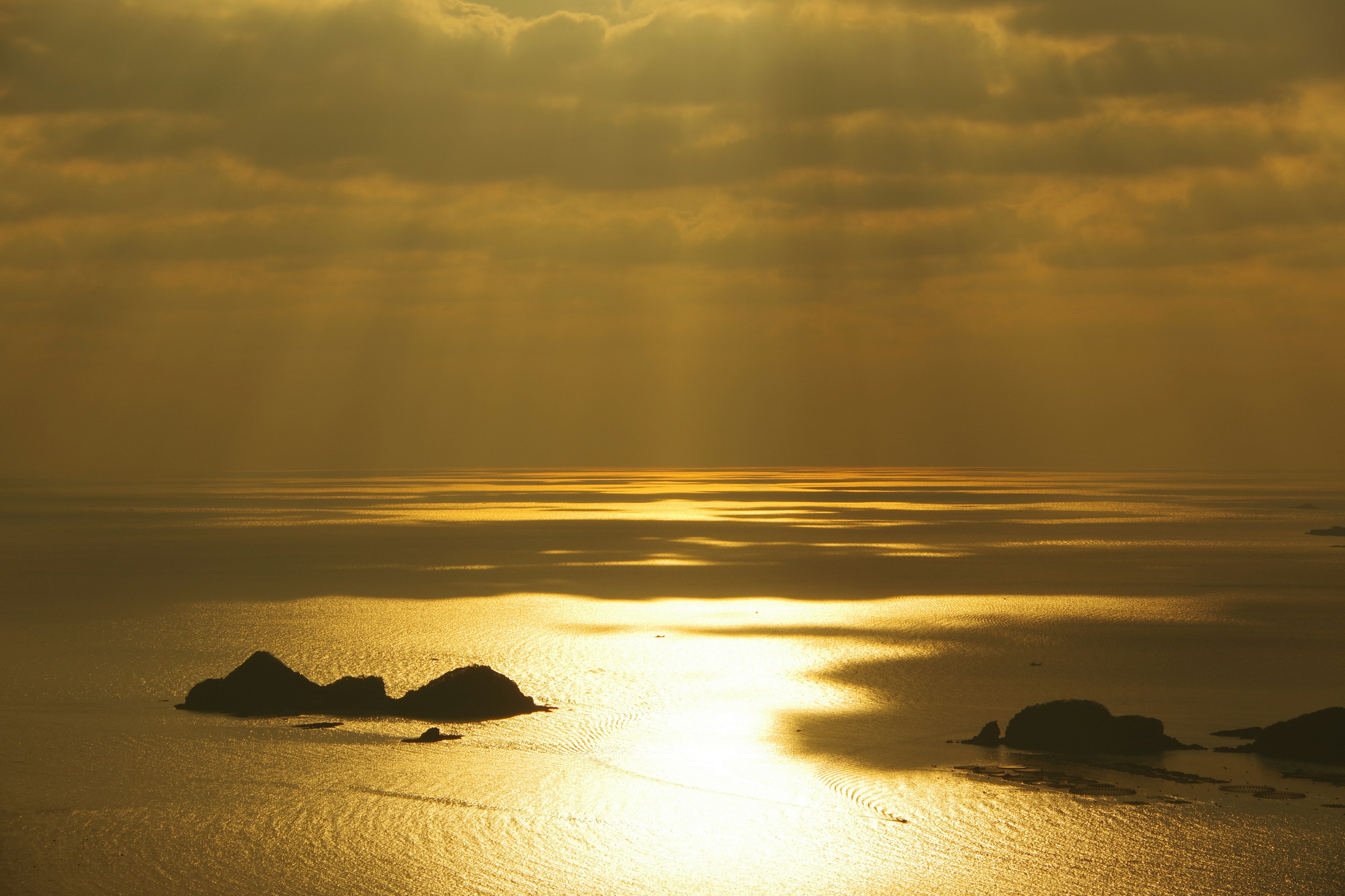 Vista del mare dorato con isole e nuvole drammatiche