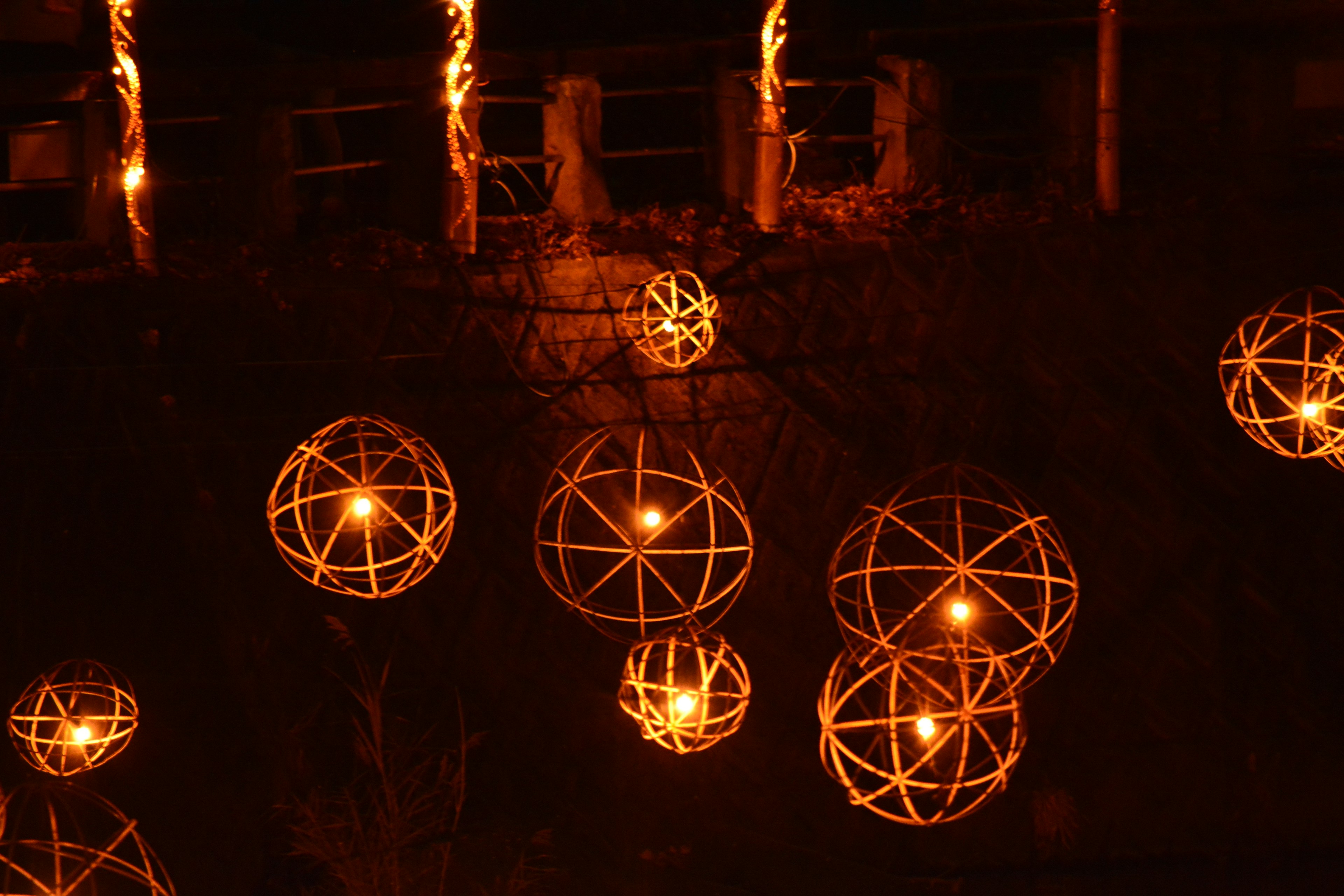 Sphères de lanternes orange ornées suspendues sur un fond sombre