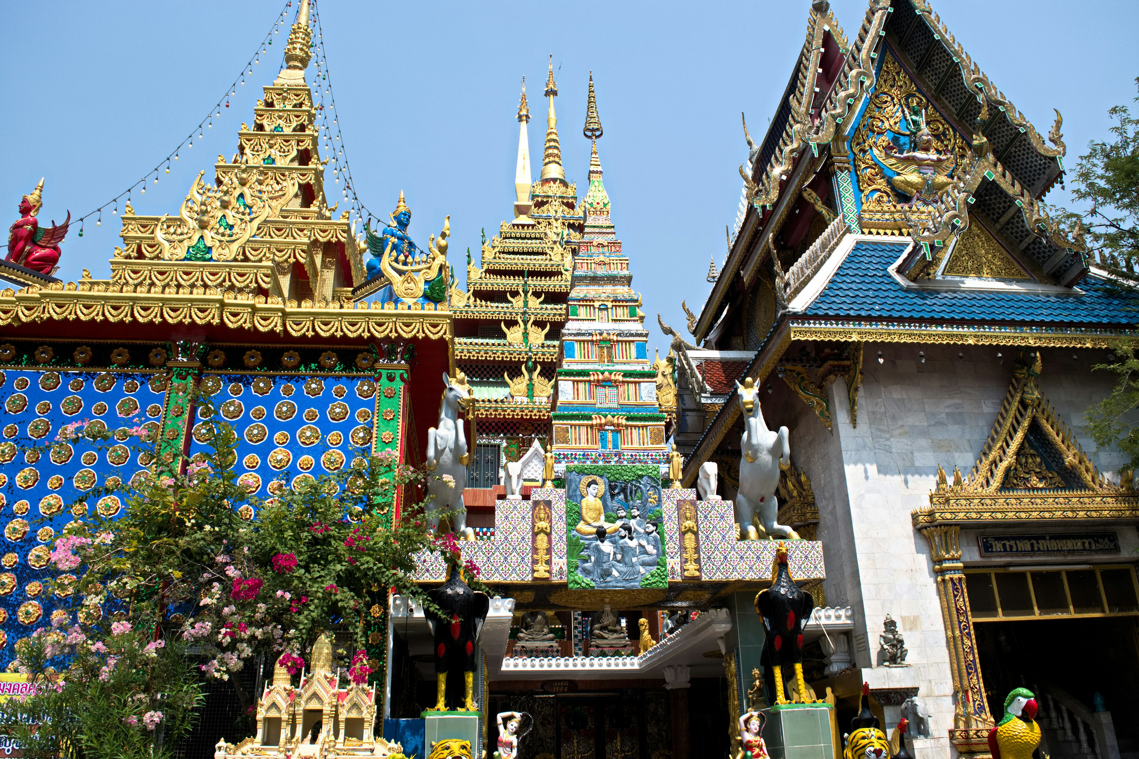 Complexe de temples magnifique avec des décorations dorées toits carrelés bleus et fleurs colorées