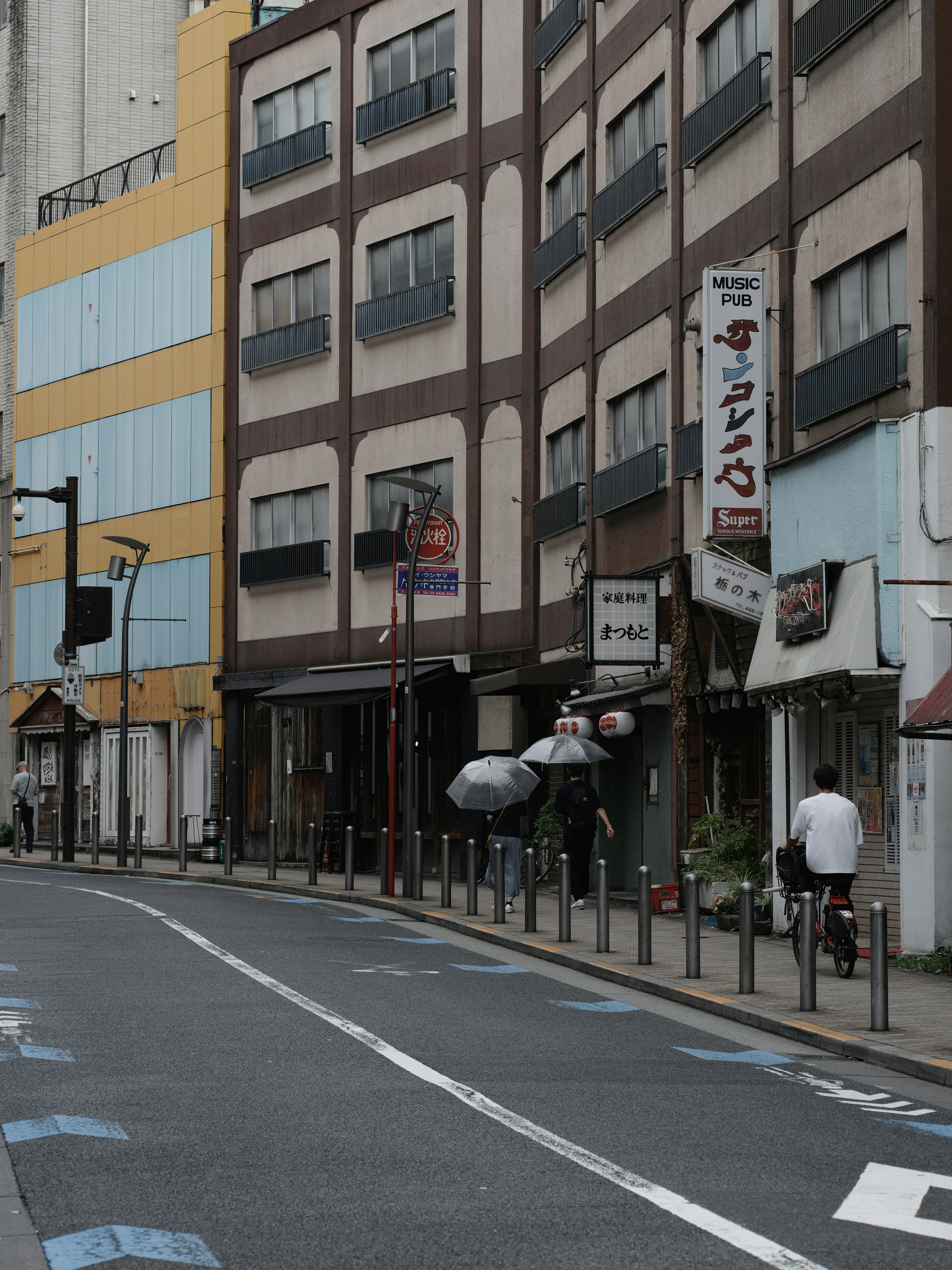 Escena urbana con edificios comerciales y ciclistas pasando