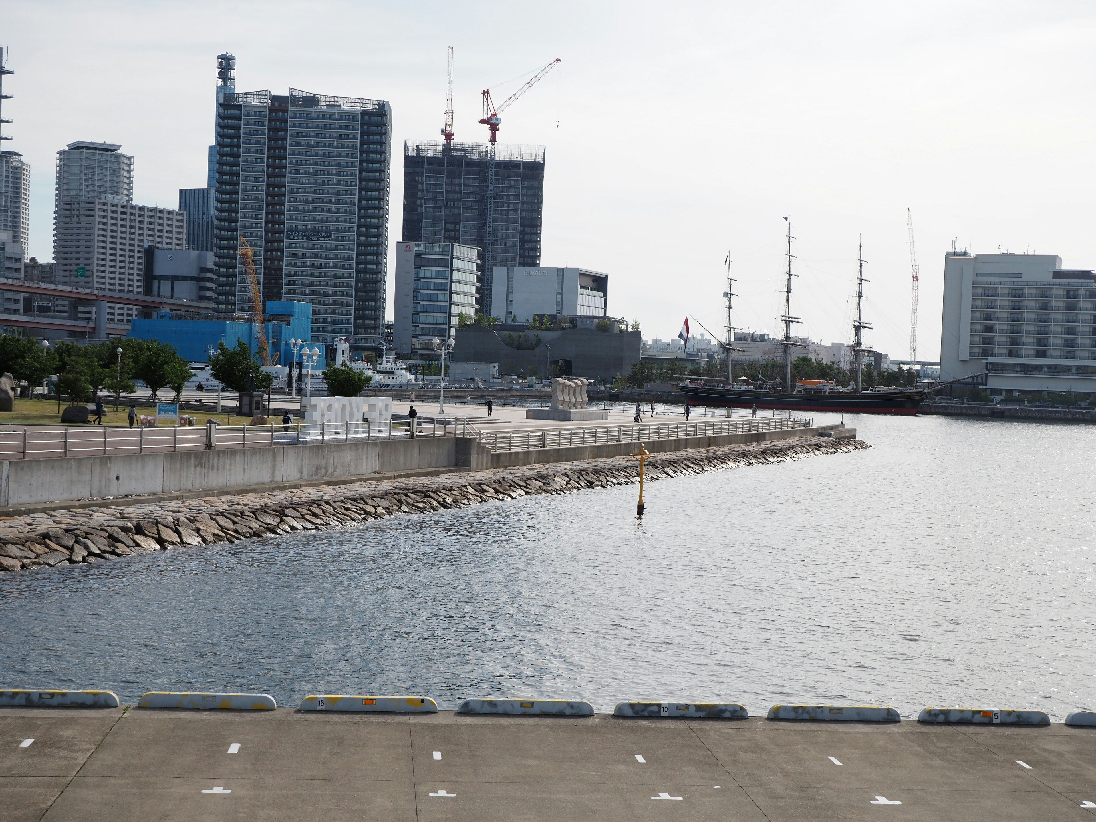 Urban waterfront view featuring high-rise buildings and yachts