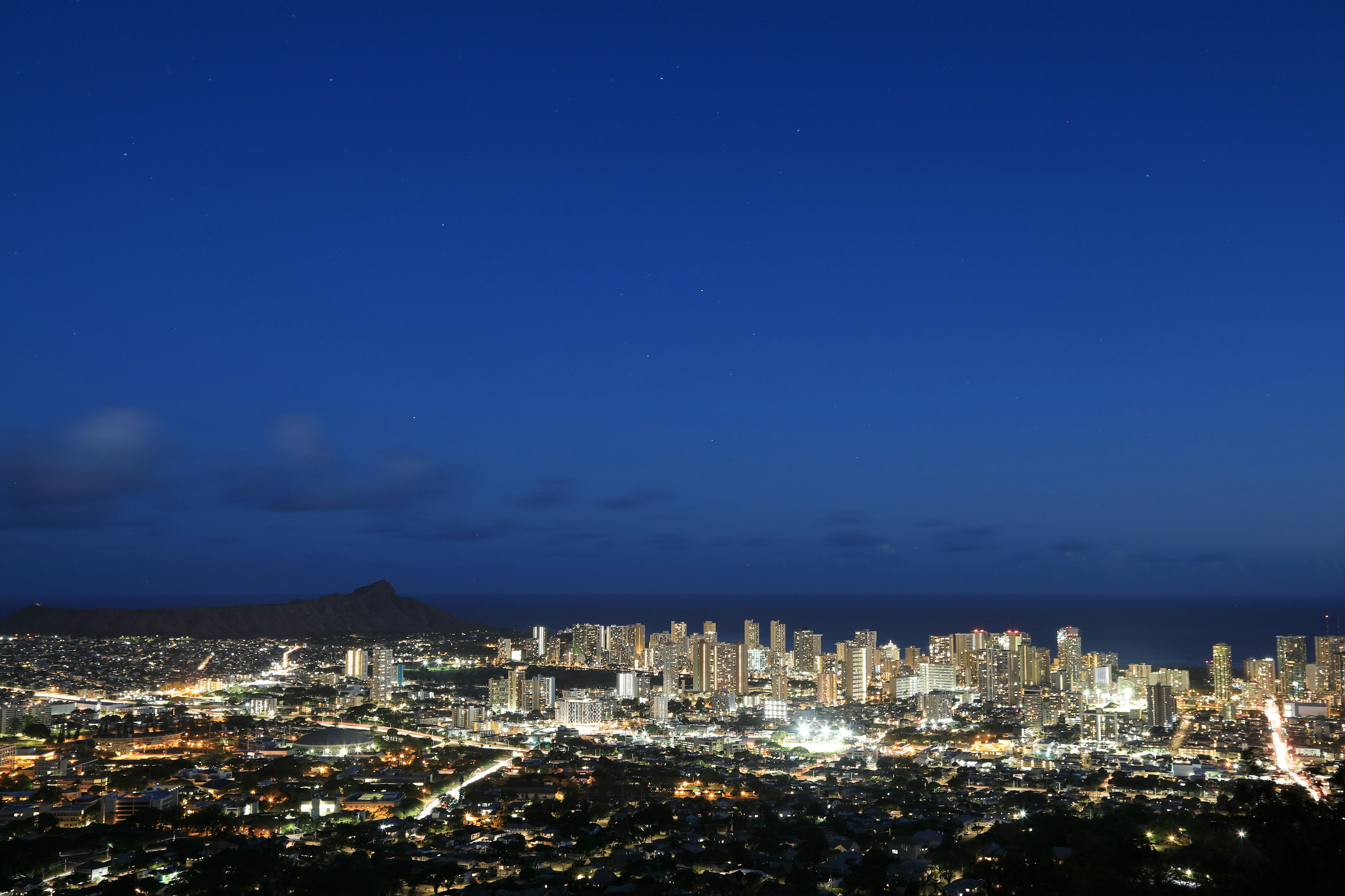 Paesaggio urbano notturno con luci brillanti e cielo blu