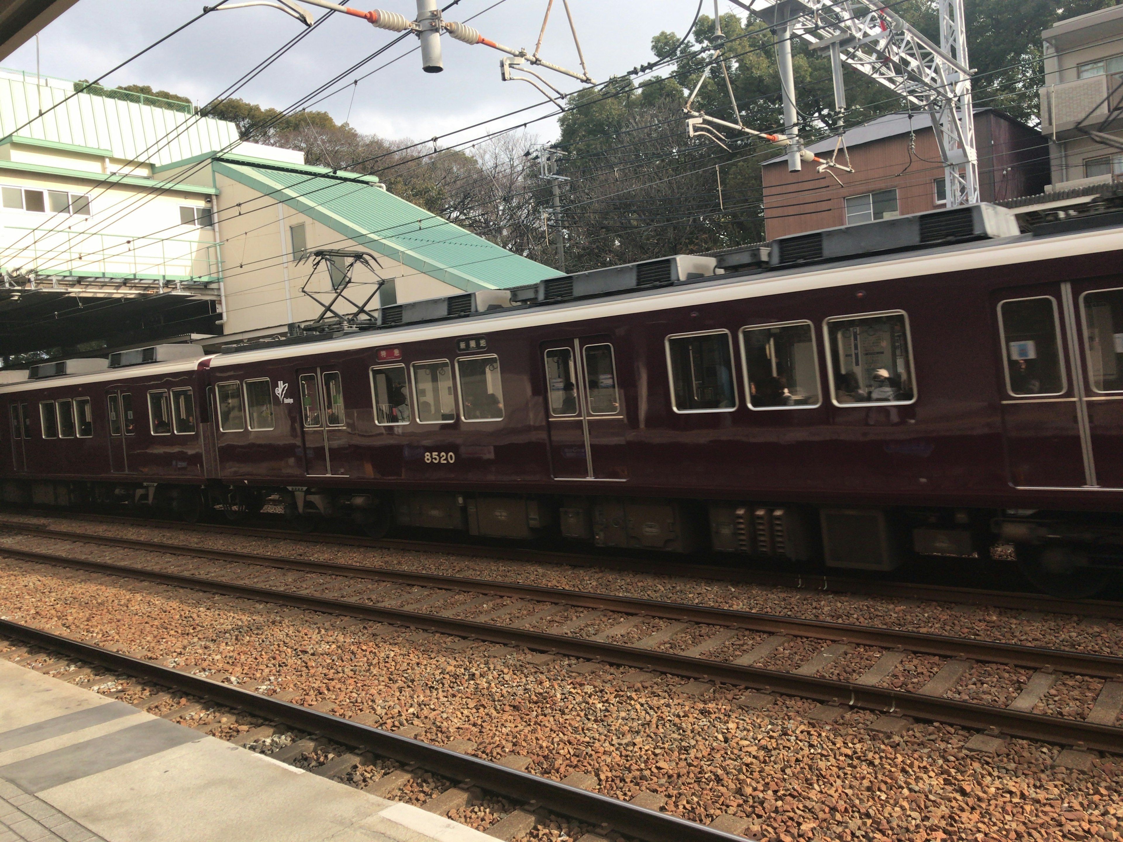 Train parked at a station platform with a maroon color