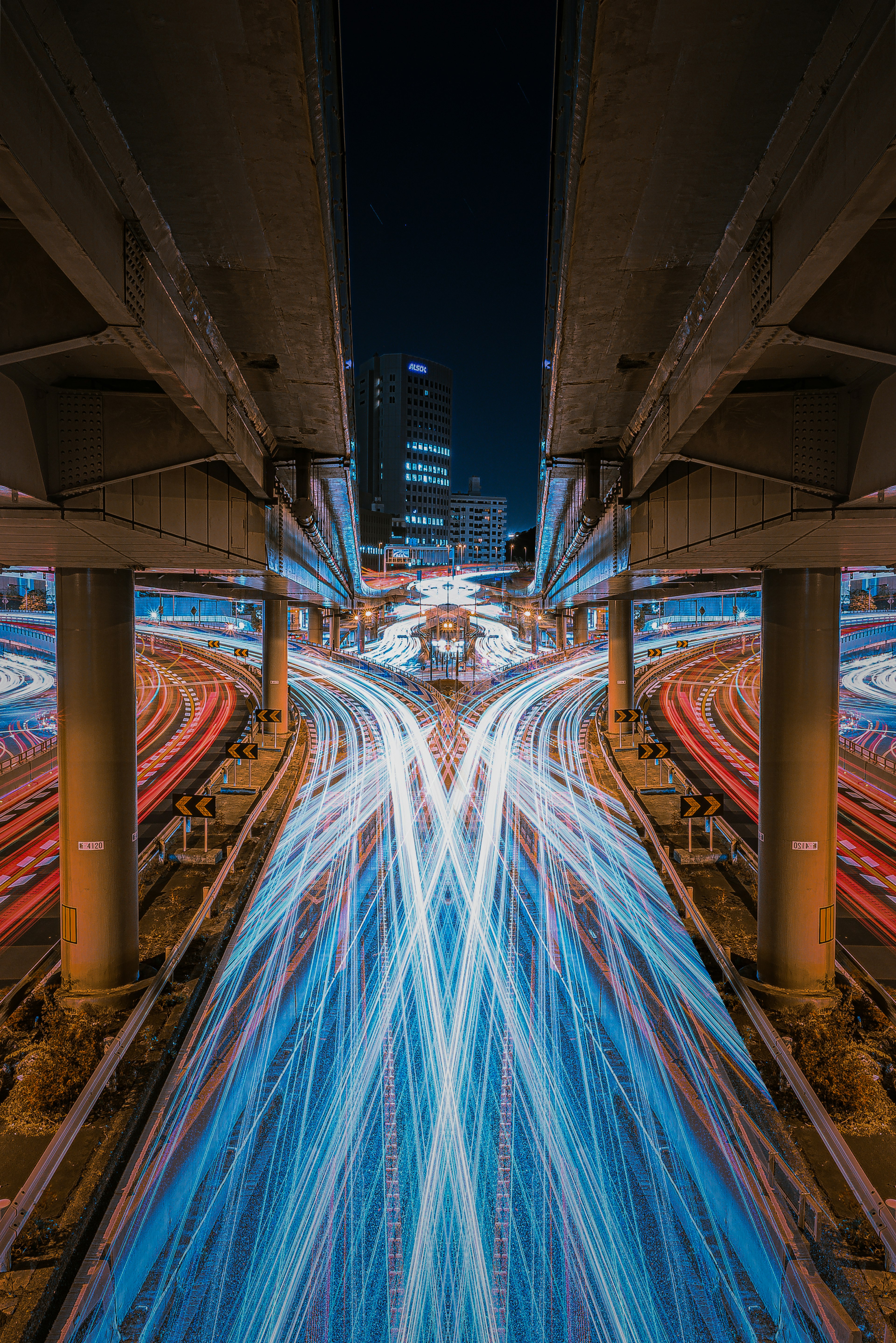 Nighttime urban highway with intersecting light trails