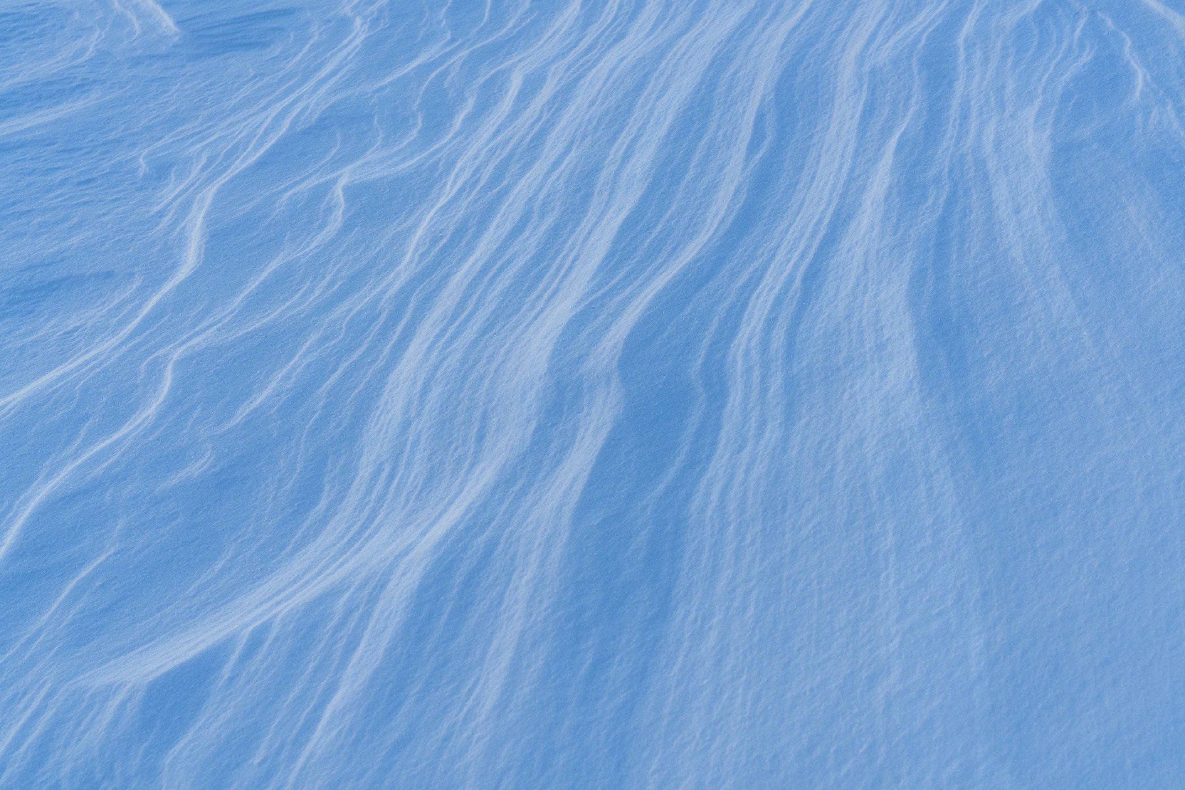 Smooth patterns and flowing texture of blue snow surface