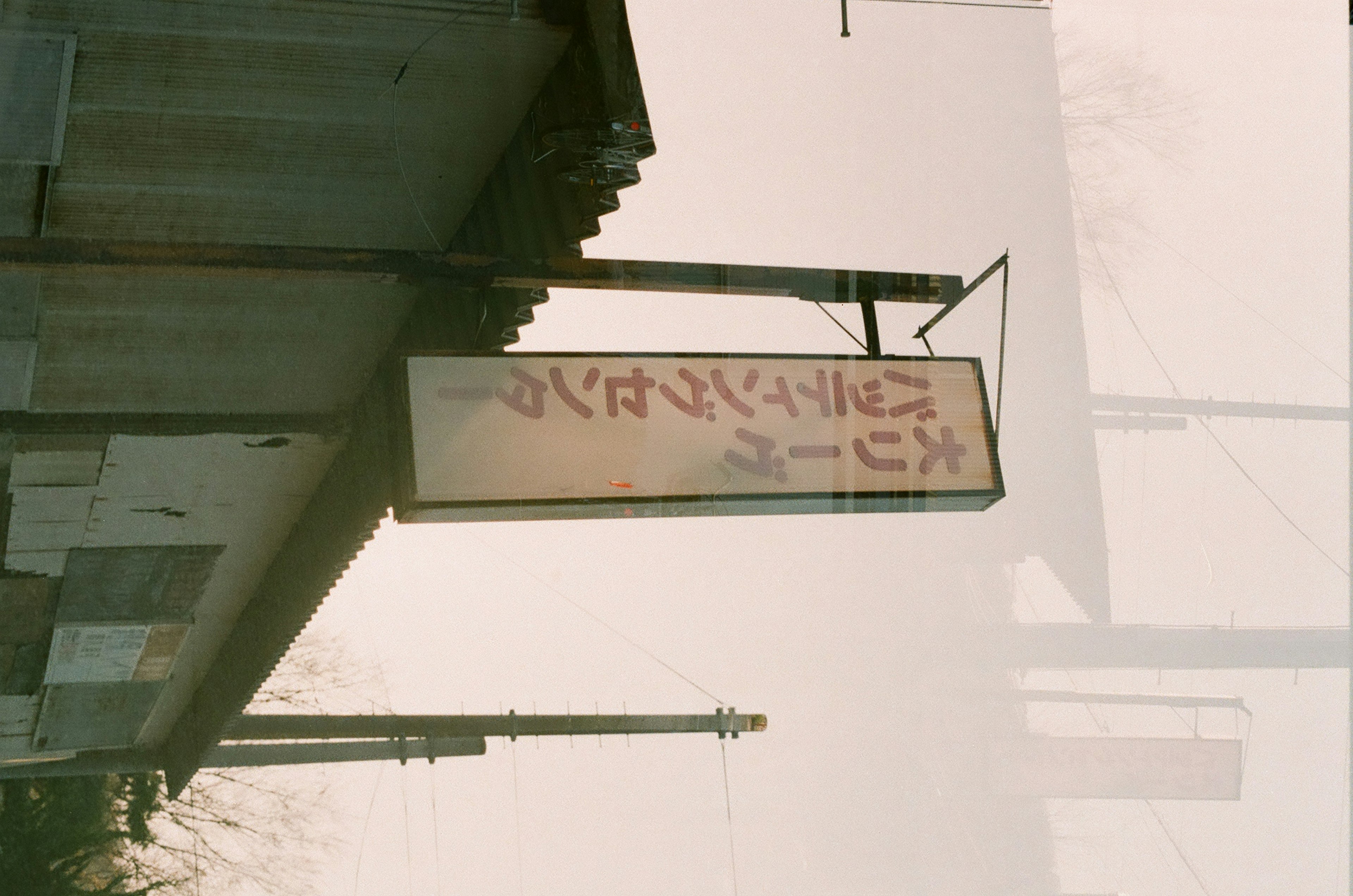 Photo of an old sign hanging against a blurred background