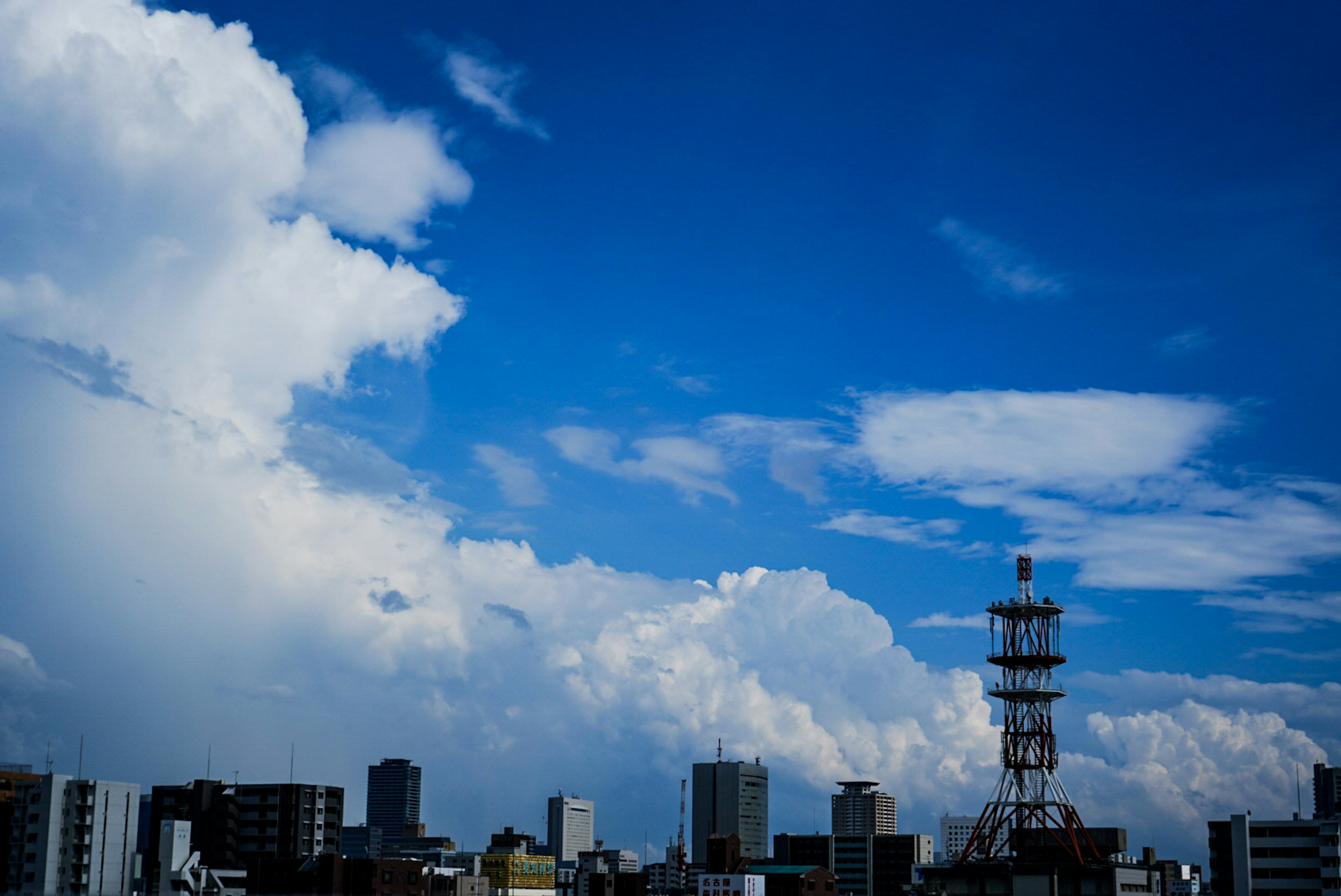 青い空と白い雲が広がる都市の風景