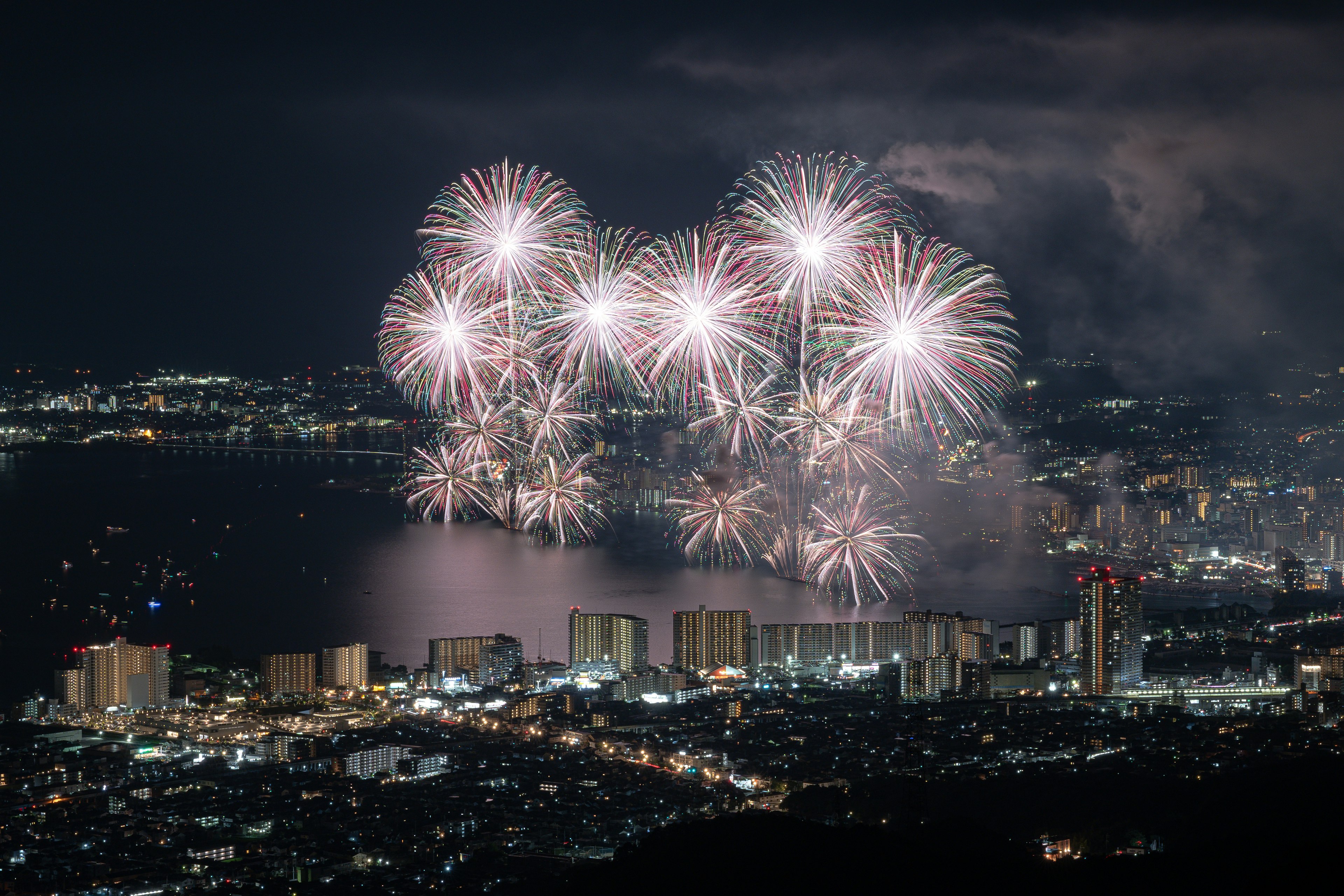 夜空を彩る花火と都市の灯りが映える美しい風景