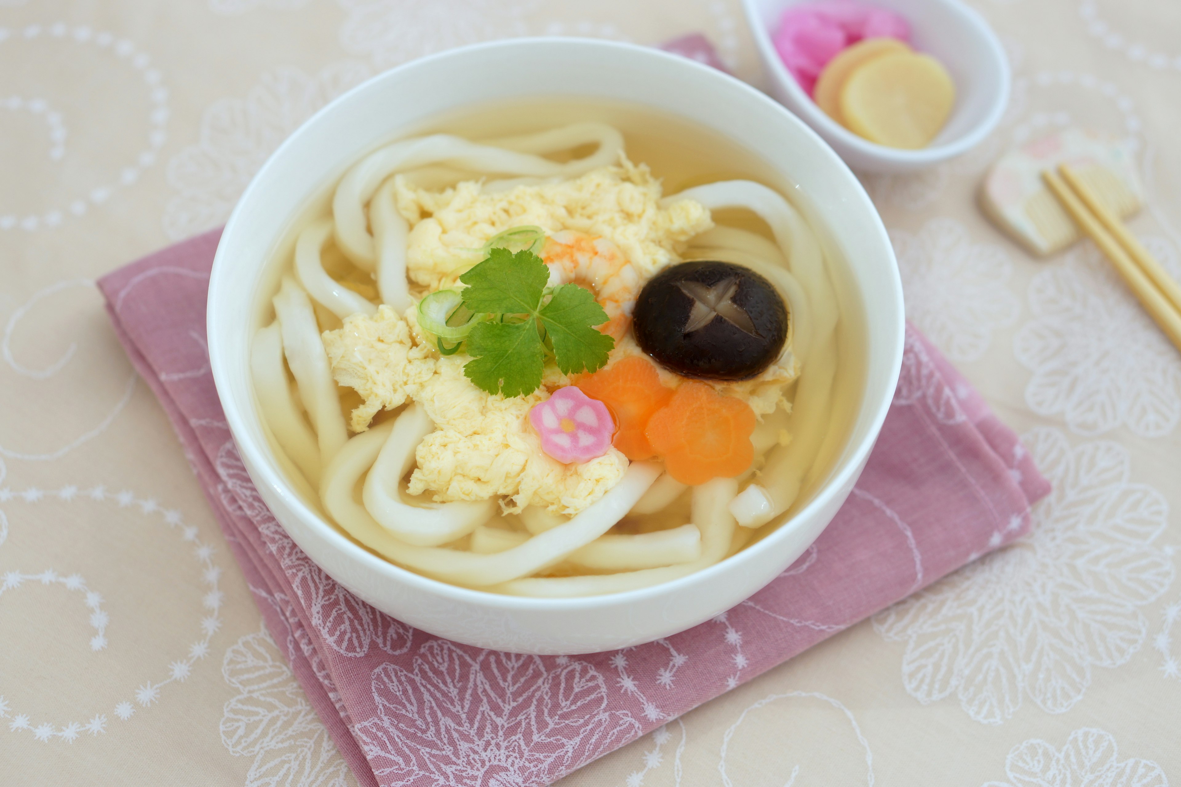 Bol de nouilles udon garni d'œuf, de champignon shiitake, de carotte et de coriandre