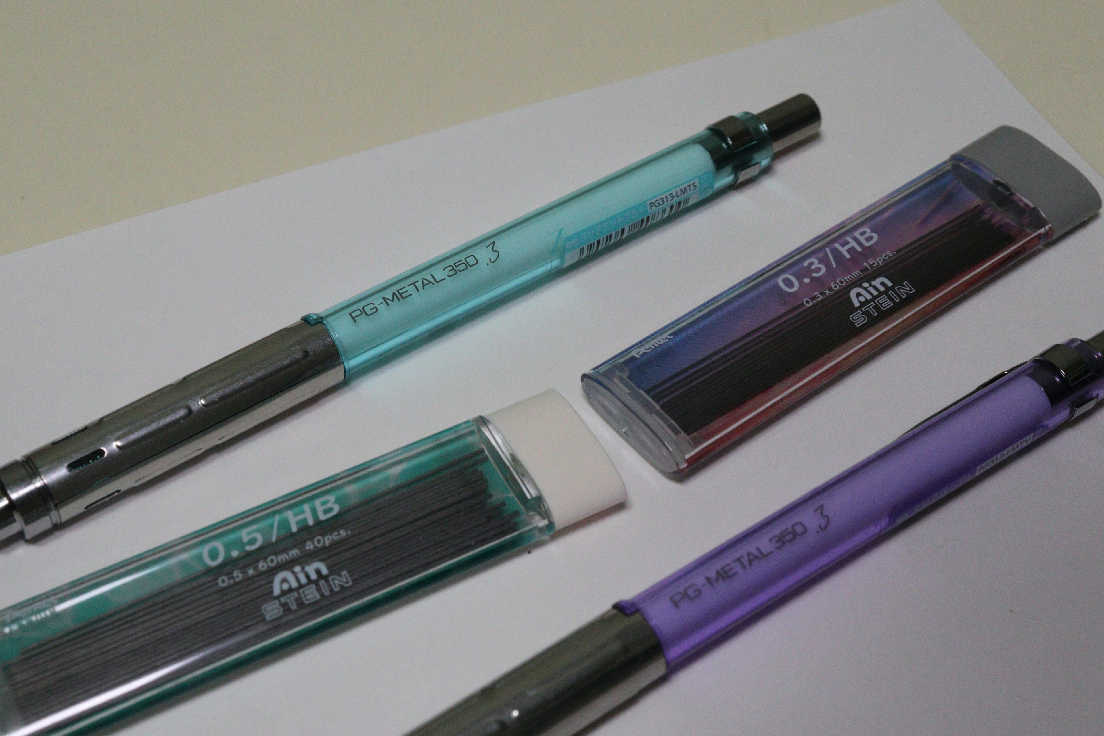 Stylos bleu et violet avec une gomme sur un fond blanc