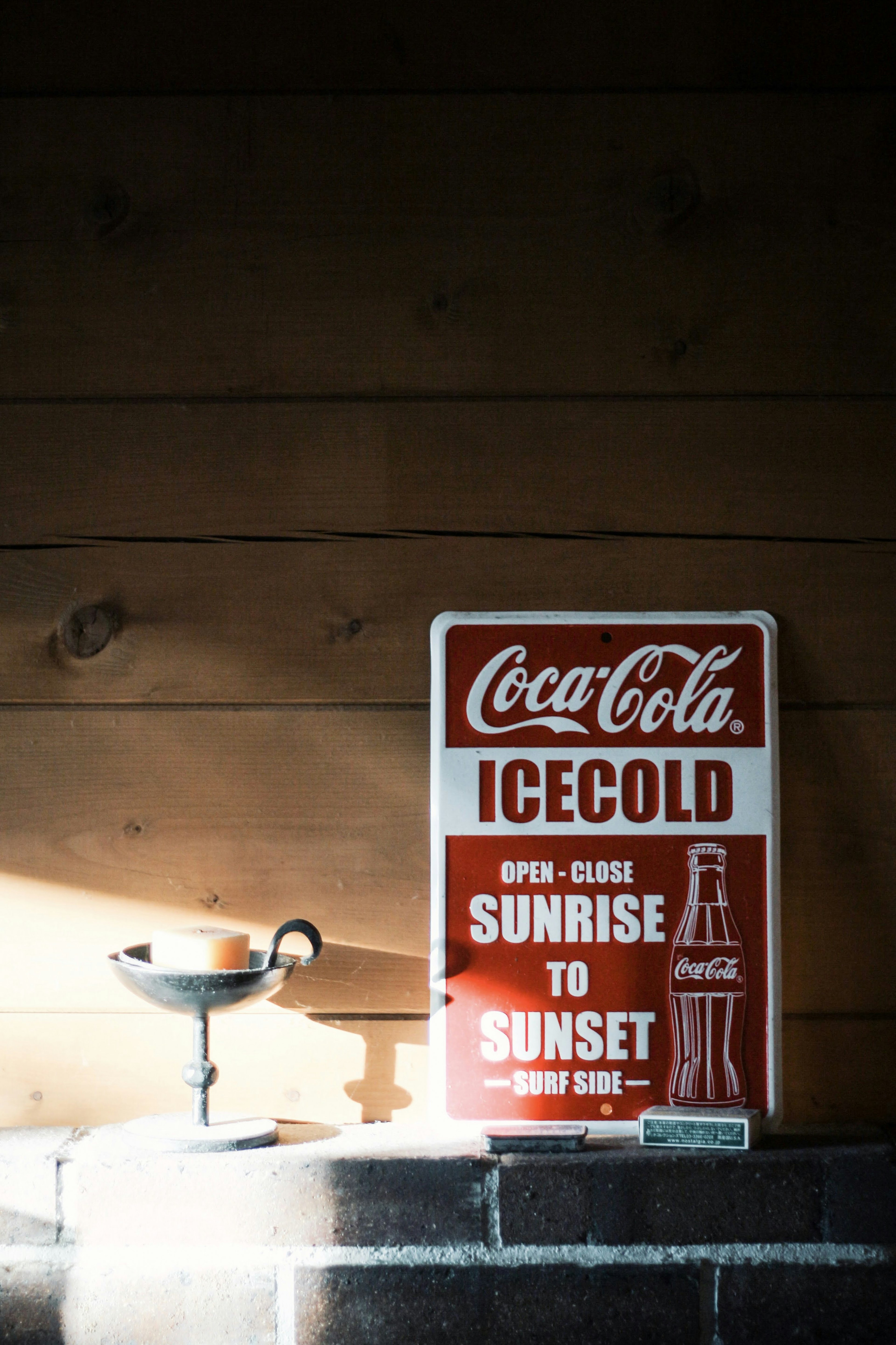 Coca-Cola ice-cold Schild vor einer Holzwand platziert