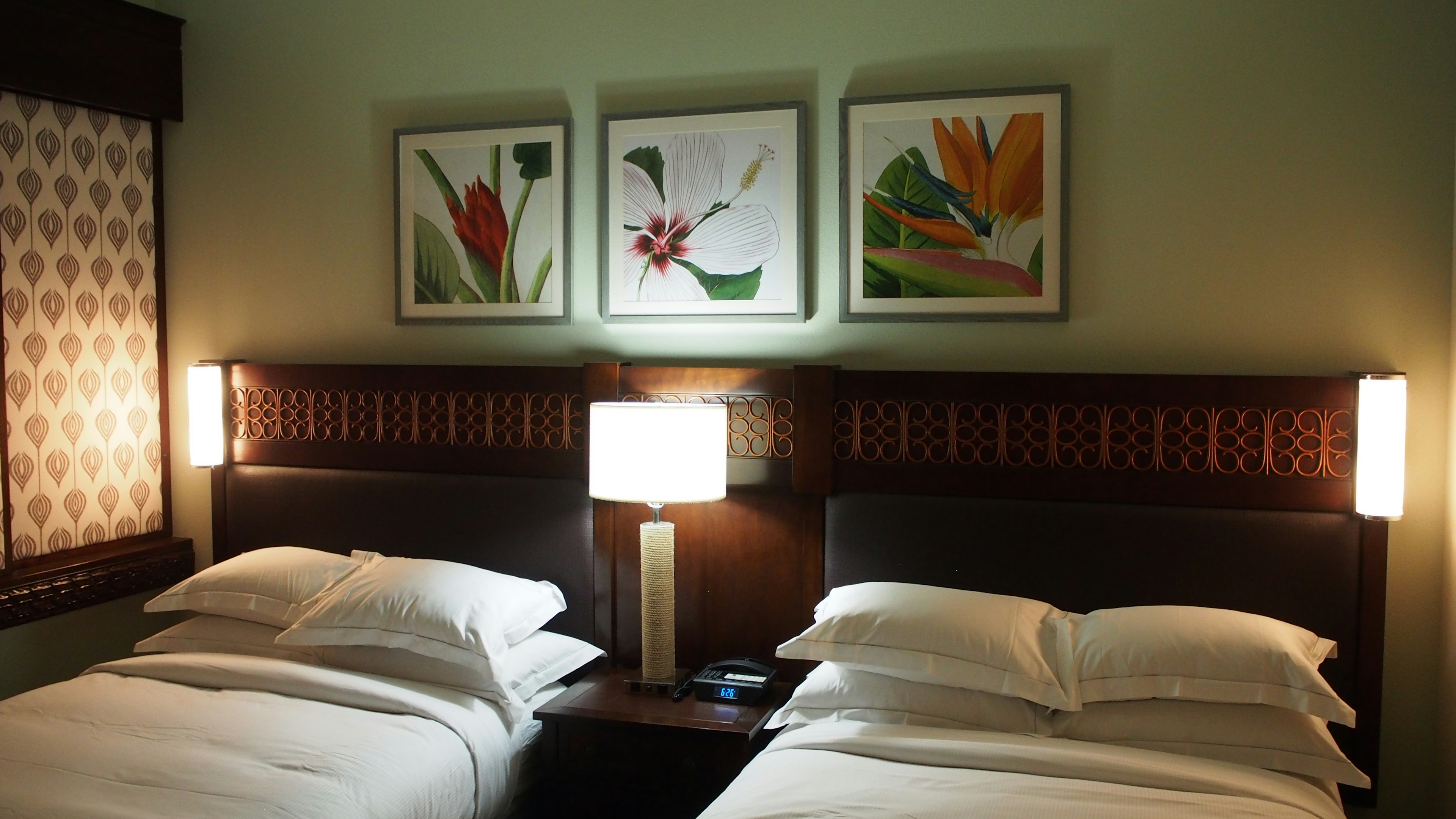 Twin bedroom with floral artwork on the wall Soft lighting and calm color scheme