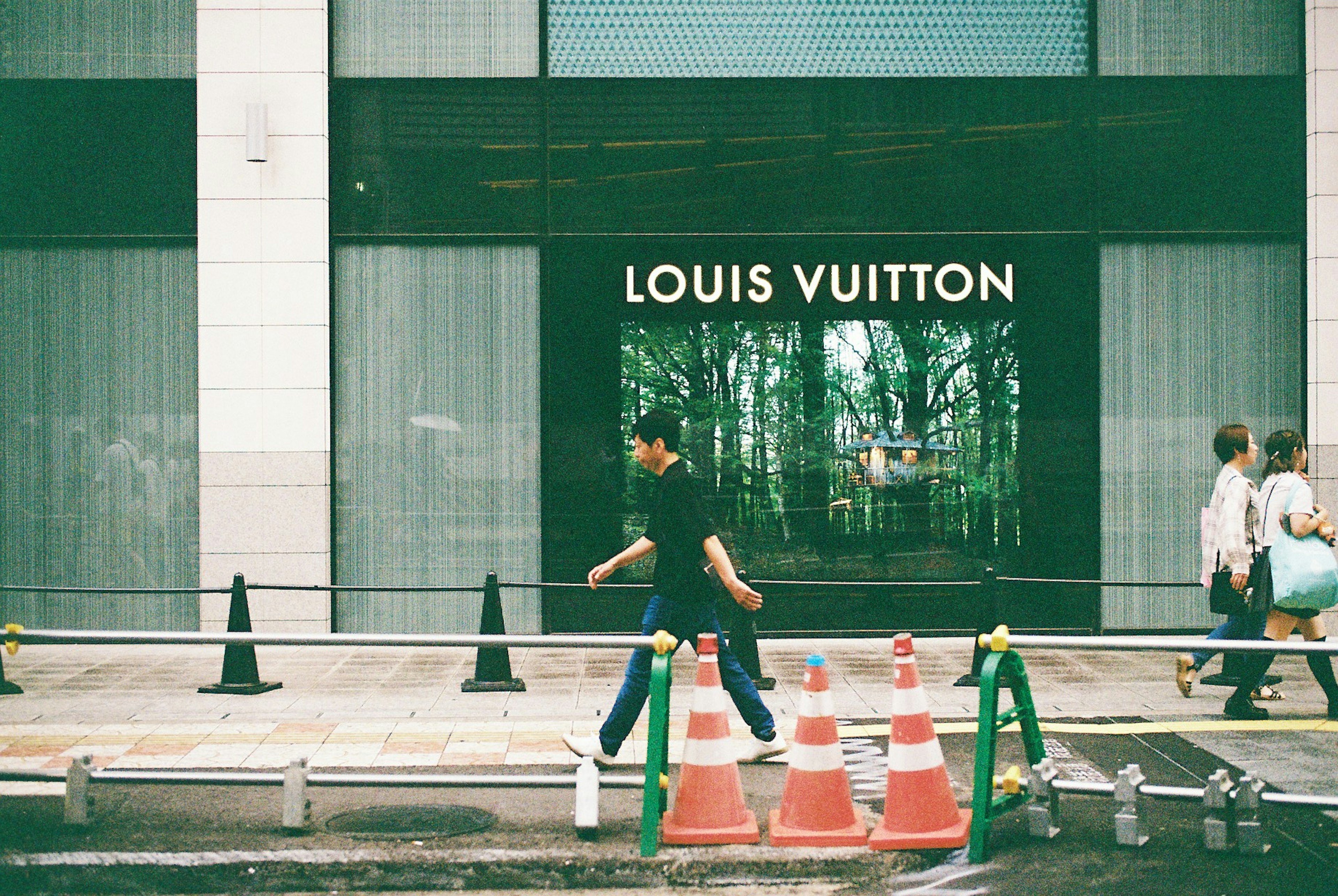 Orang-orang berjalan di jalan di depan toko Louis Vuitton