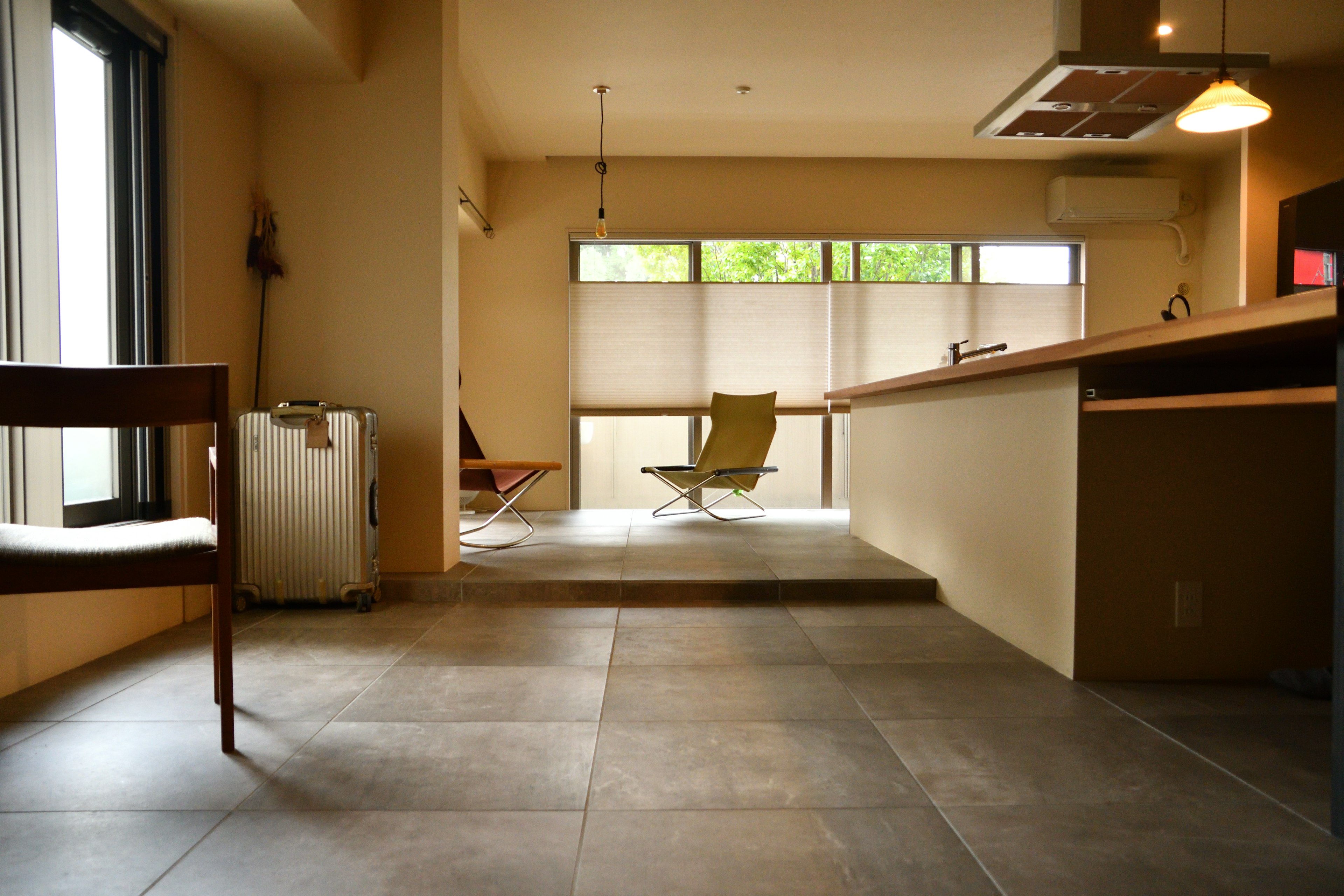 Sala de estar moderna y minimalista con suelo de baldosas grandes ventanas que dejan entrar luz natural