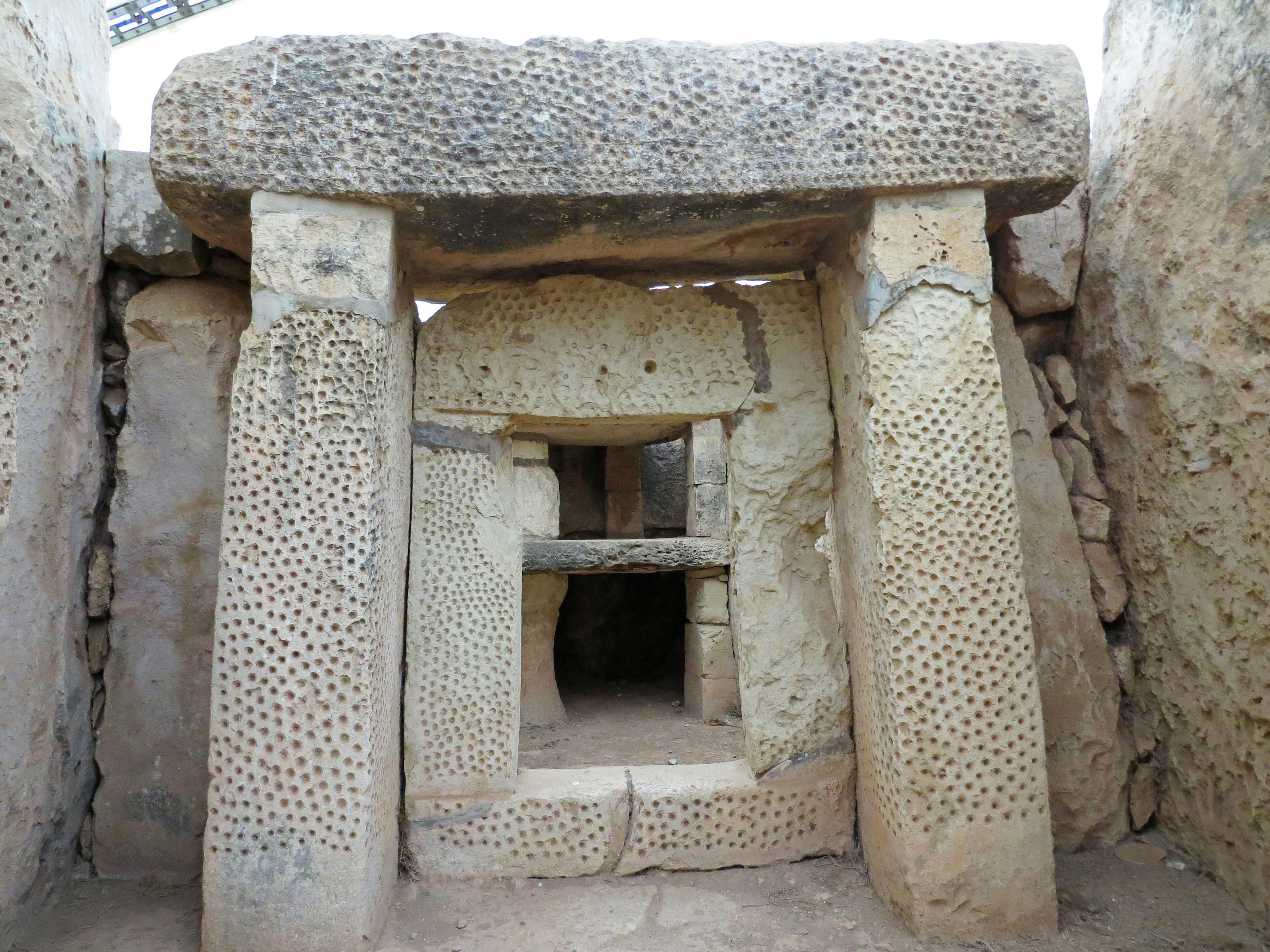 Interno di un antico monumento in pietra con colonne e soffitto scolpiti