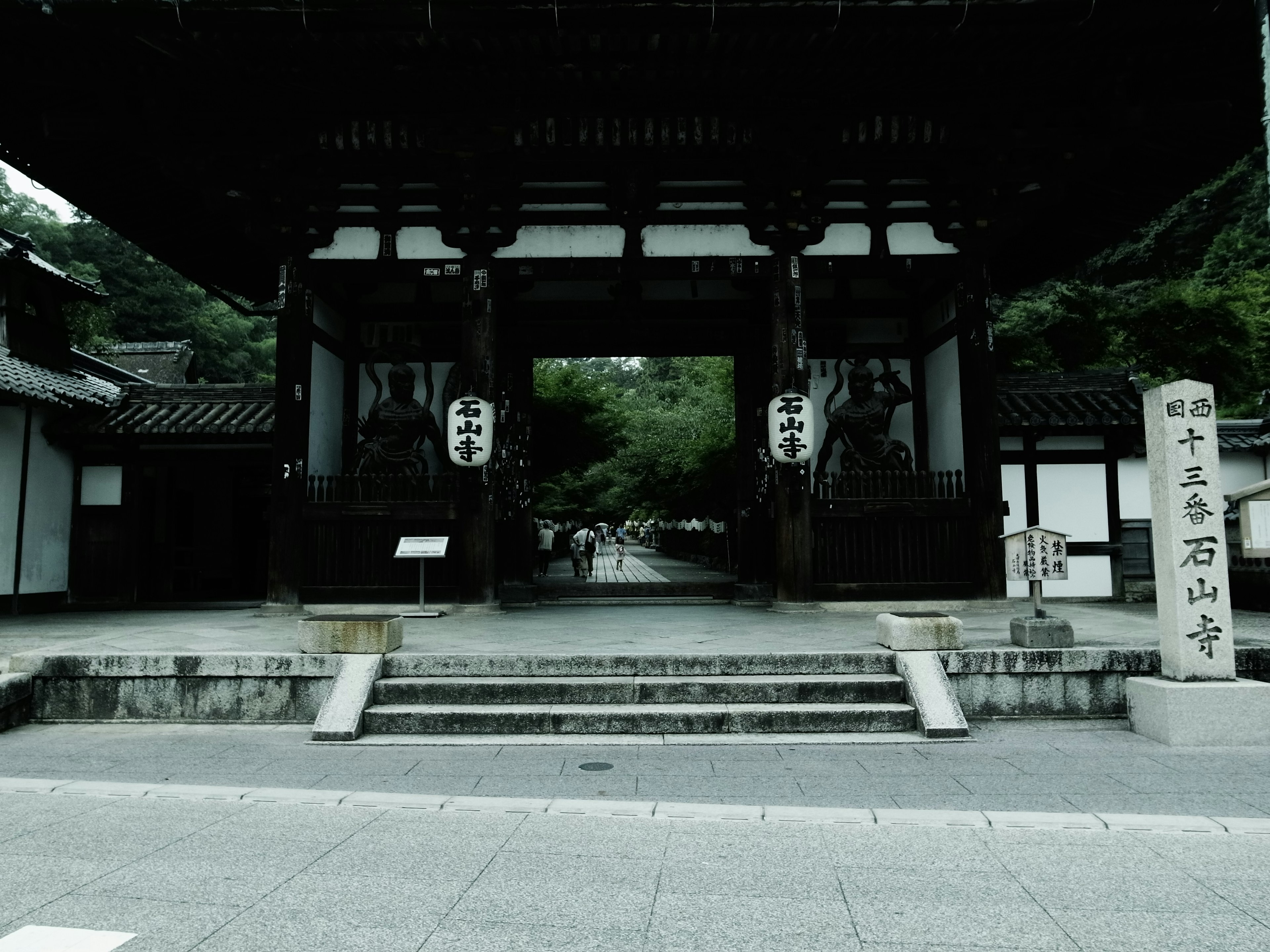 古い寺院の門と石の標識がある景色