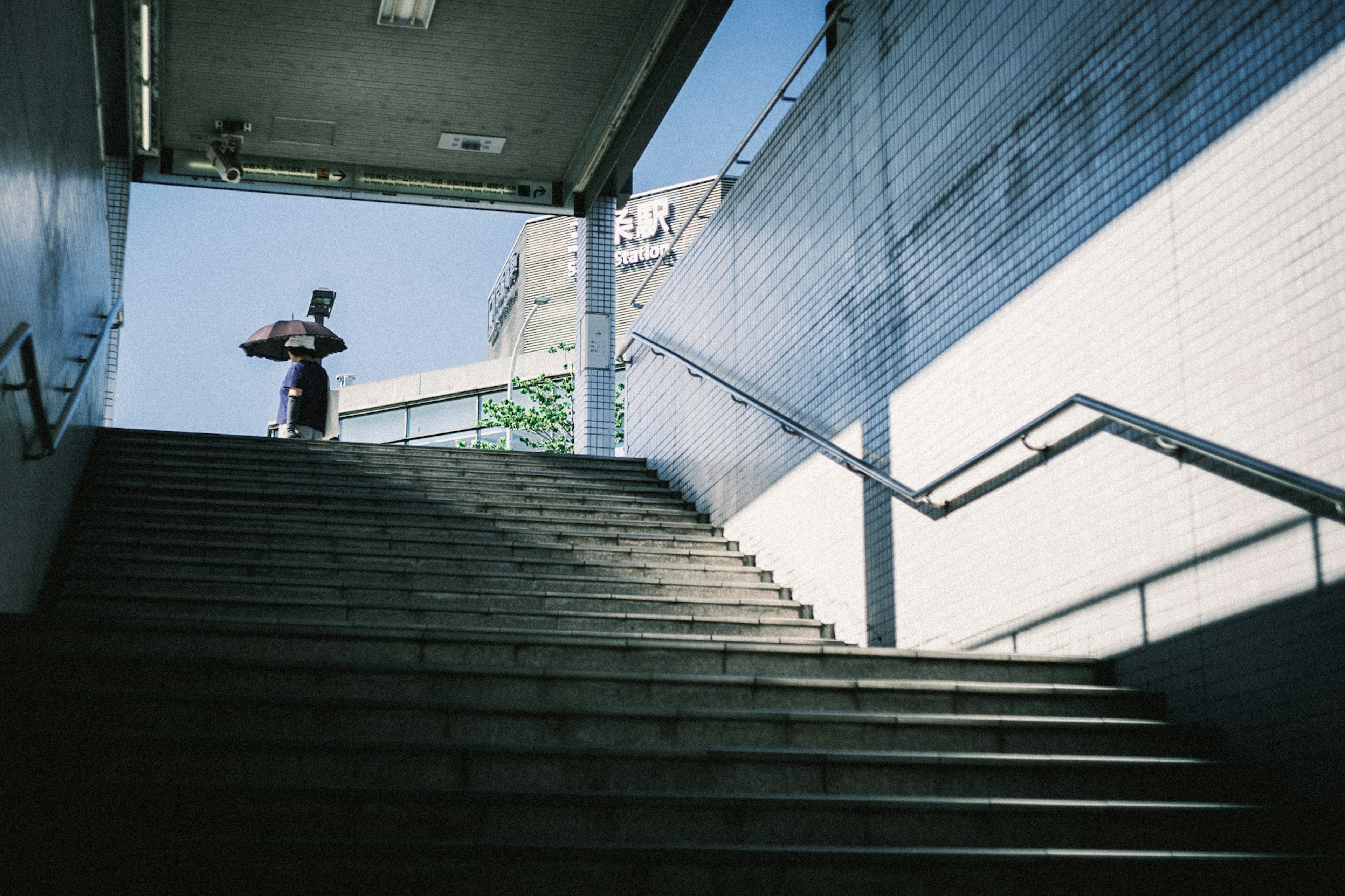 A woman walking up stairs under a clear blue sky