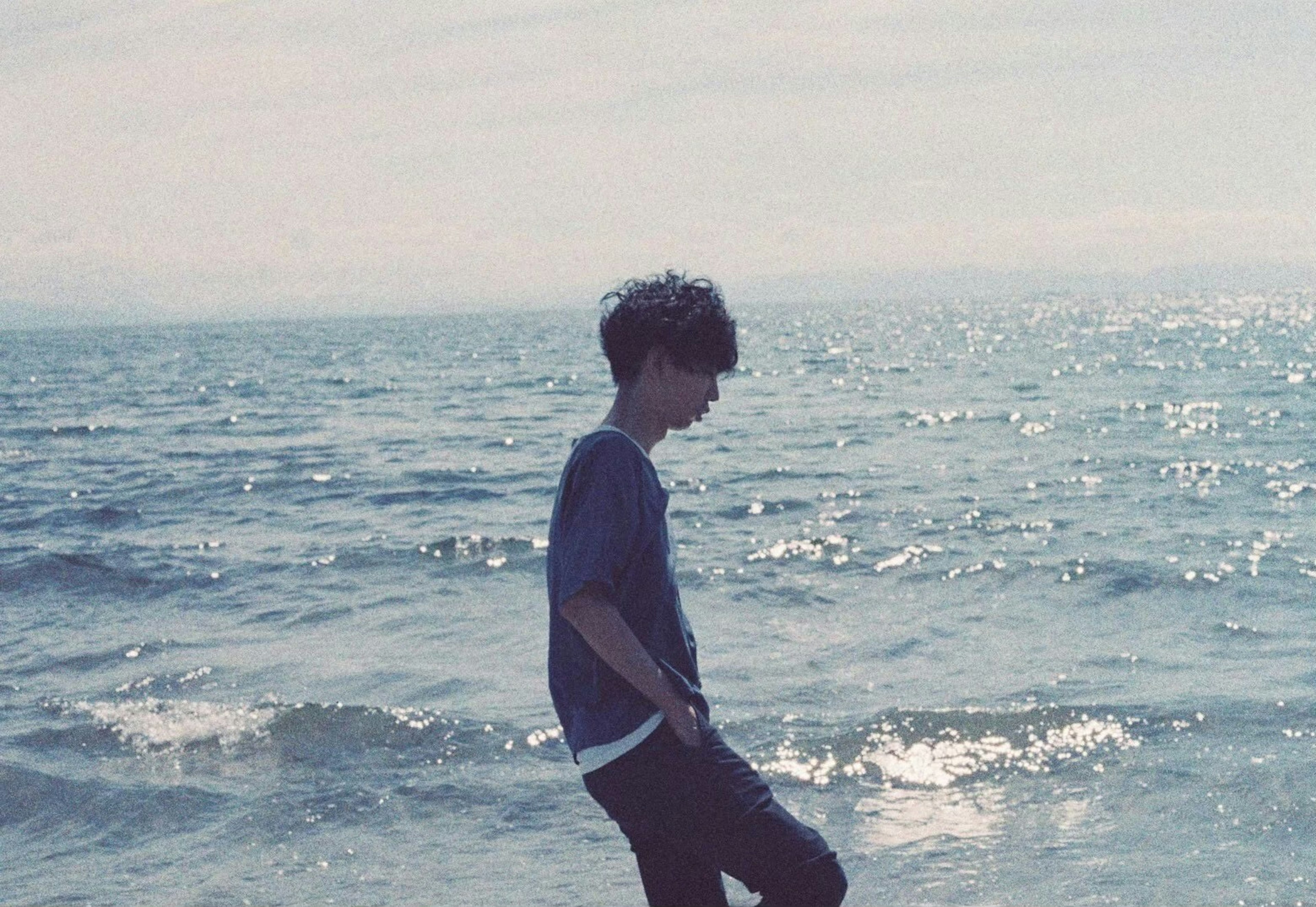 Silhouette of a young person standing by the seaside