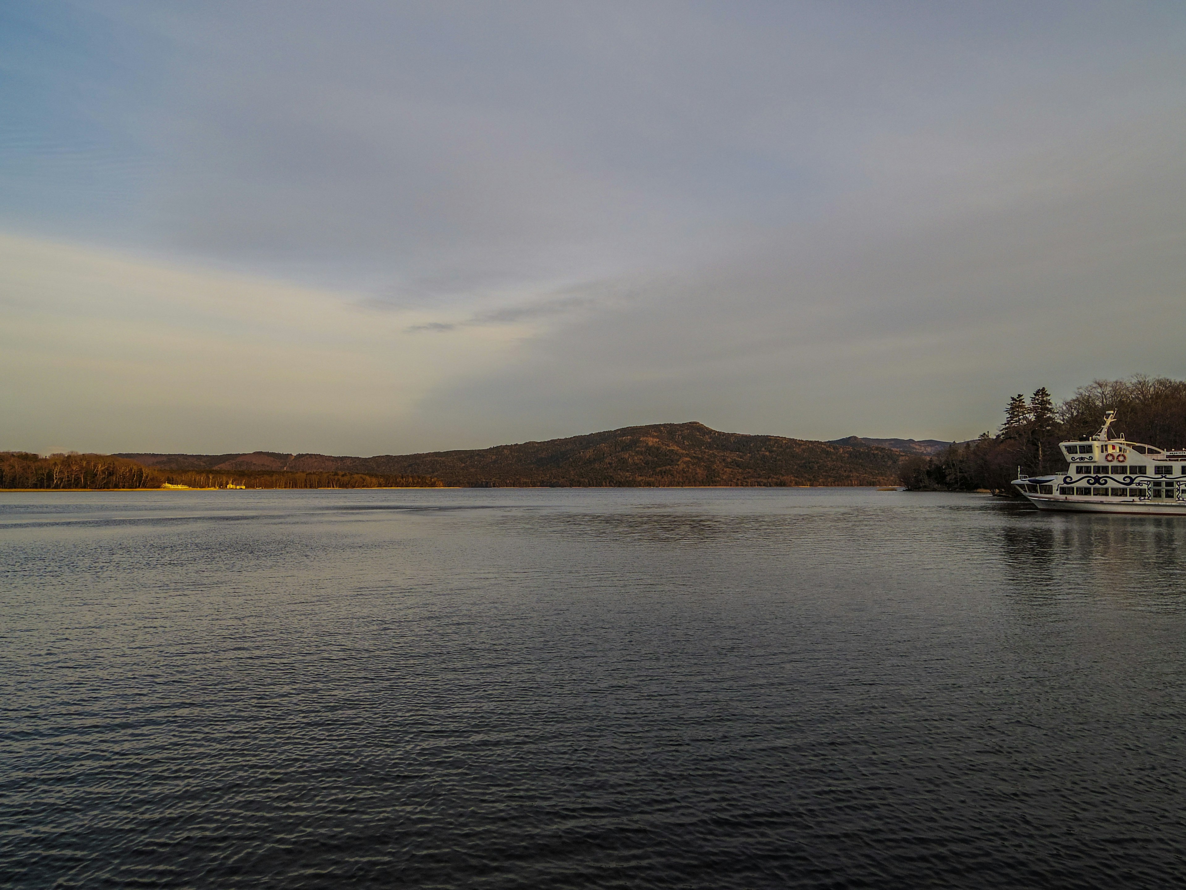 Tranquil lake view at dusk with distant hills