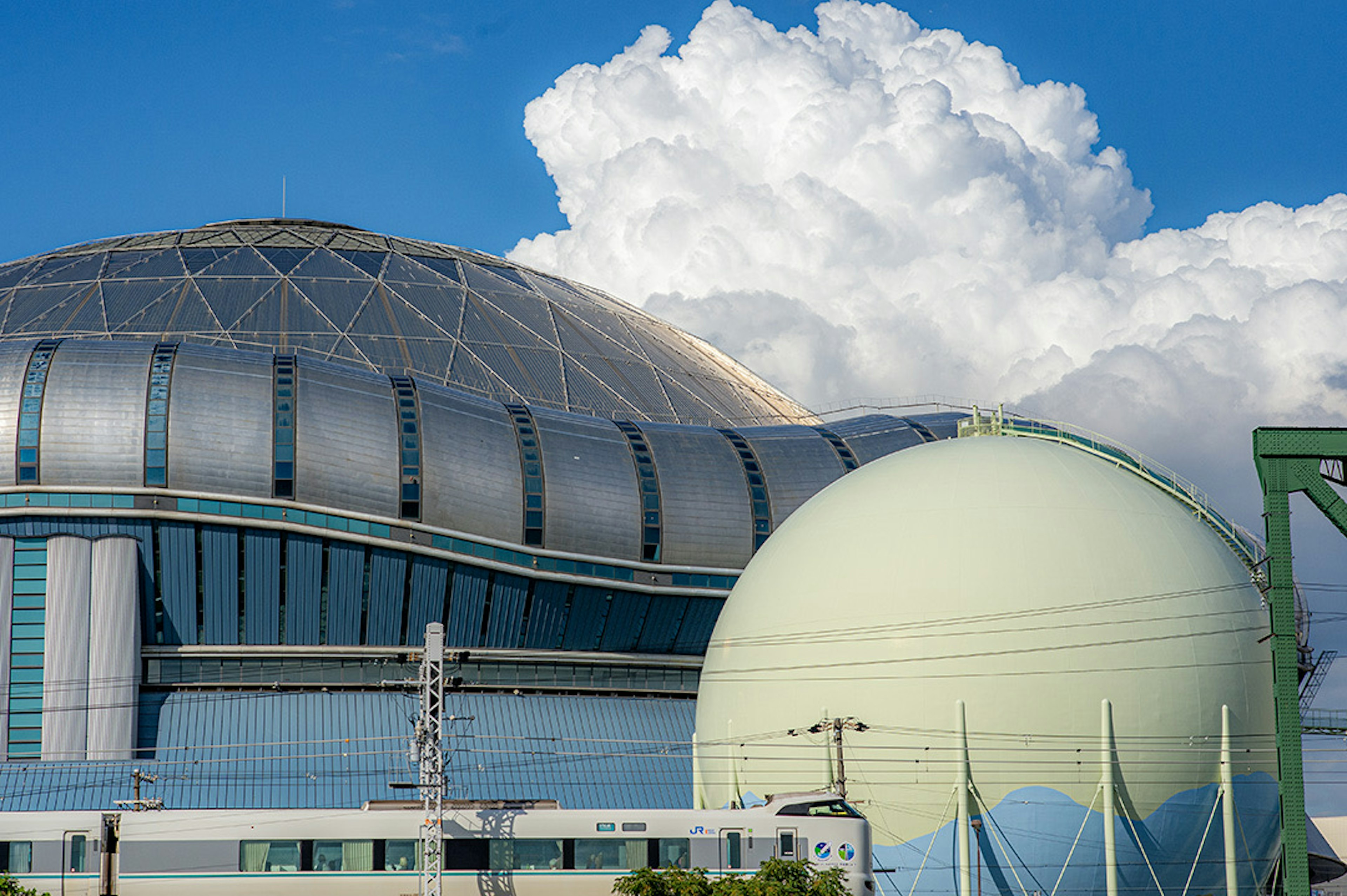 青空の下にある近代的な建物と大きな球体の構造物