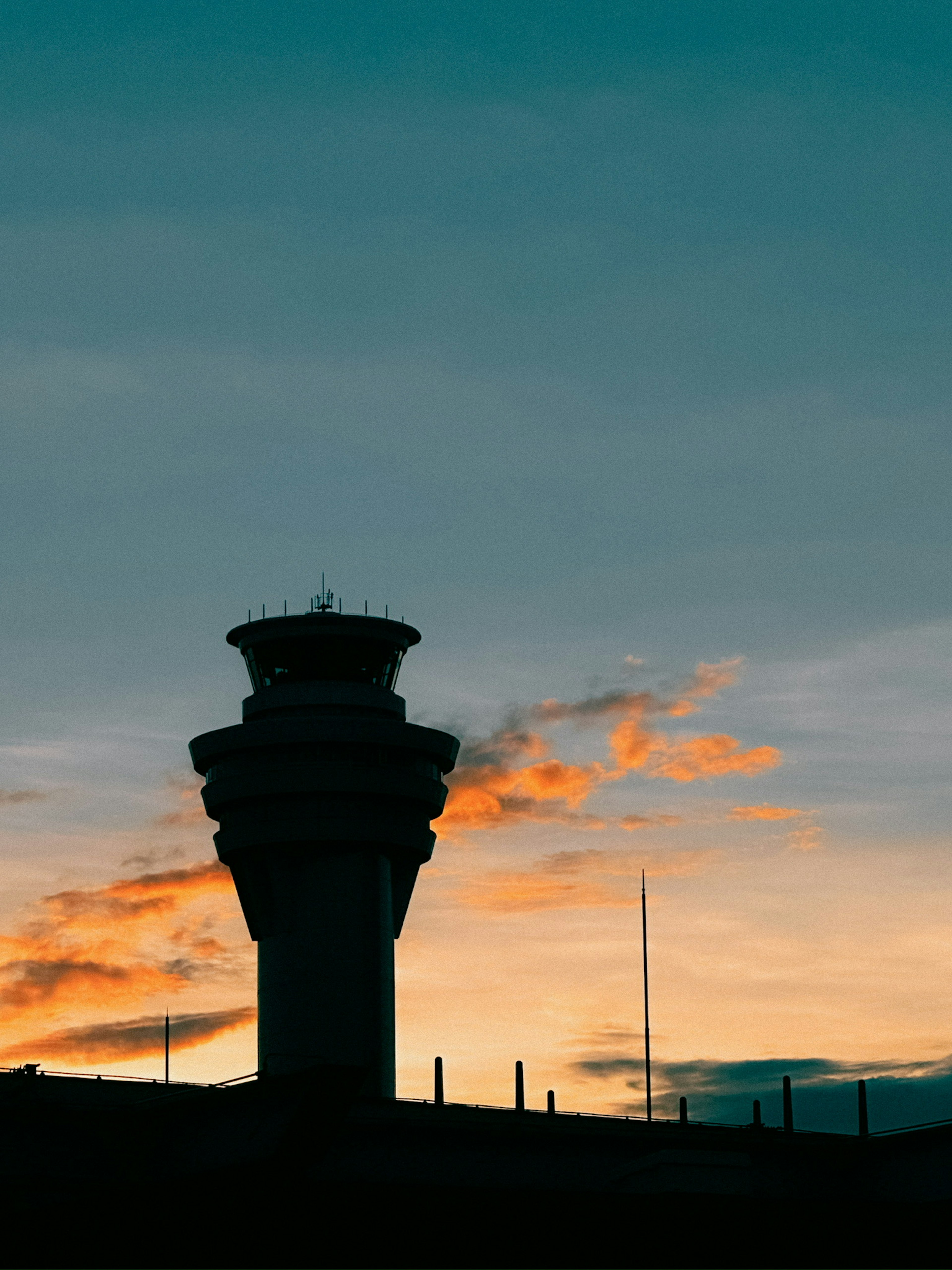 Silhouette d'une tour de contrôle d'aéroport au coucher du soleil