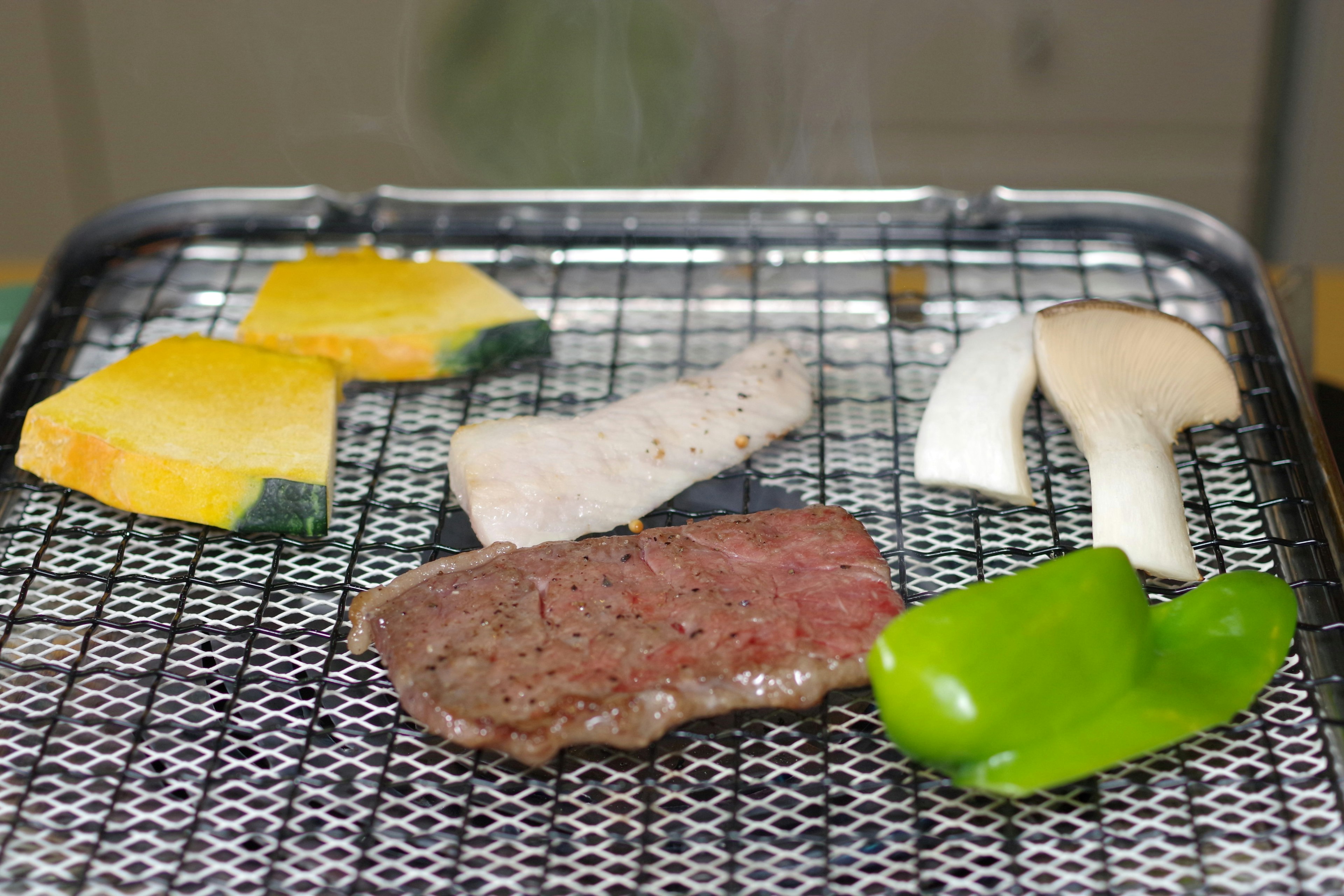 Assortiment de légumes et de viande en train de griller sur un barbecue