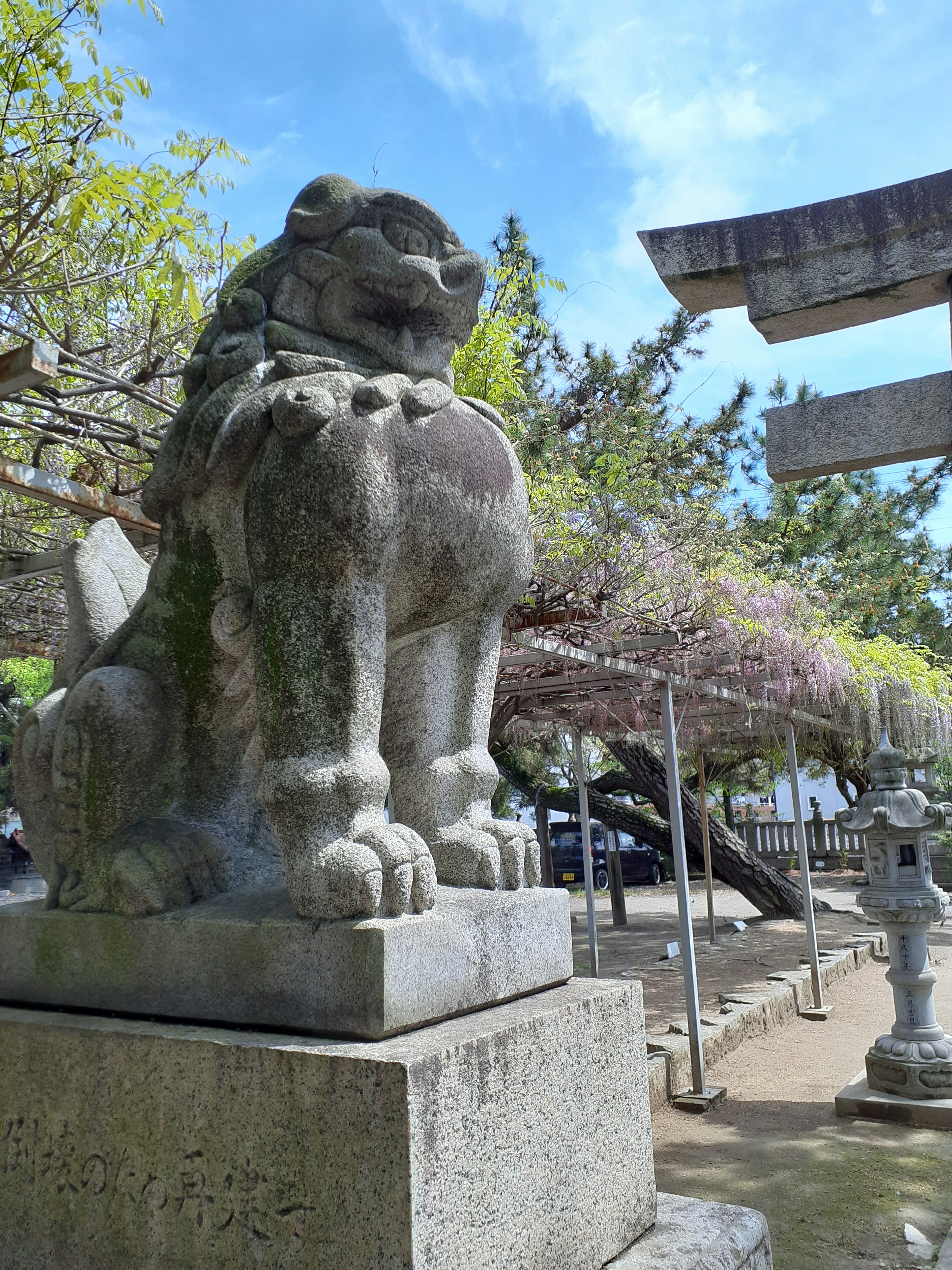 Stone statue of a komainu guardian dog in a shrine courtyard