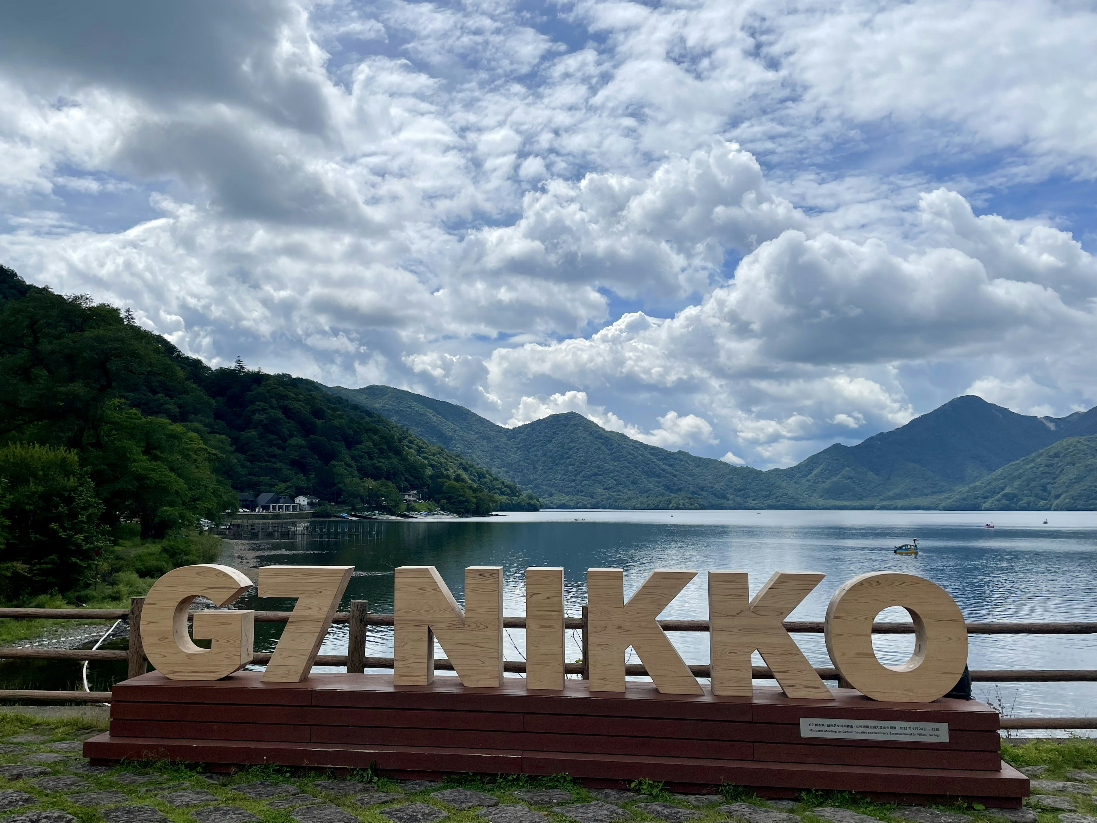 日光の湖の近くにある大きな文字の看板G7 NIKKOと美しい空の景色