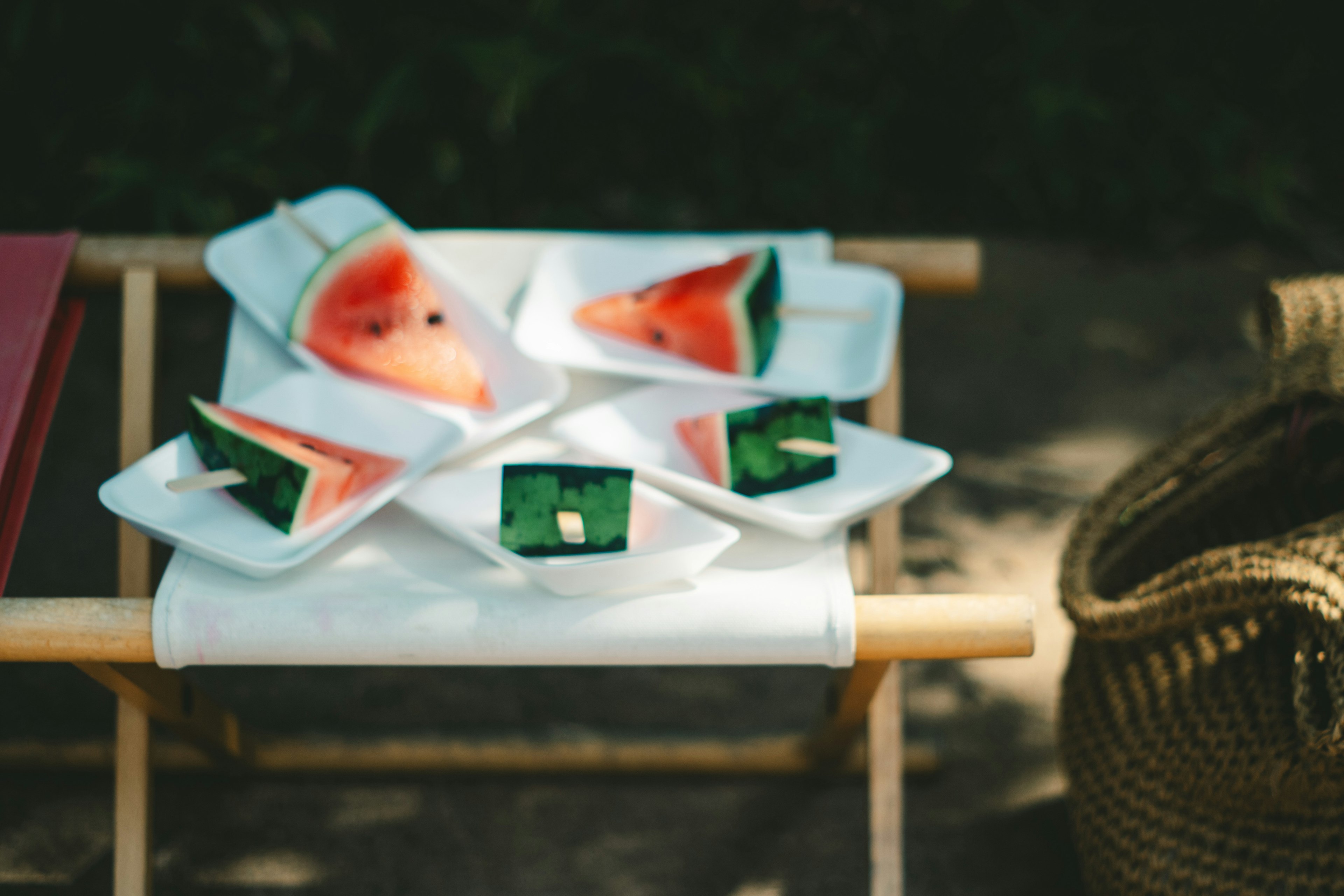 Rebanadas coloridas de sandía dispuestas en platos blancos sobre una mesa