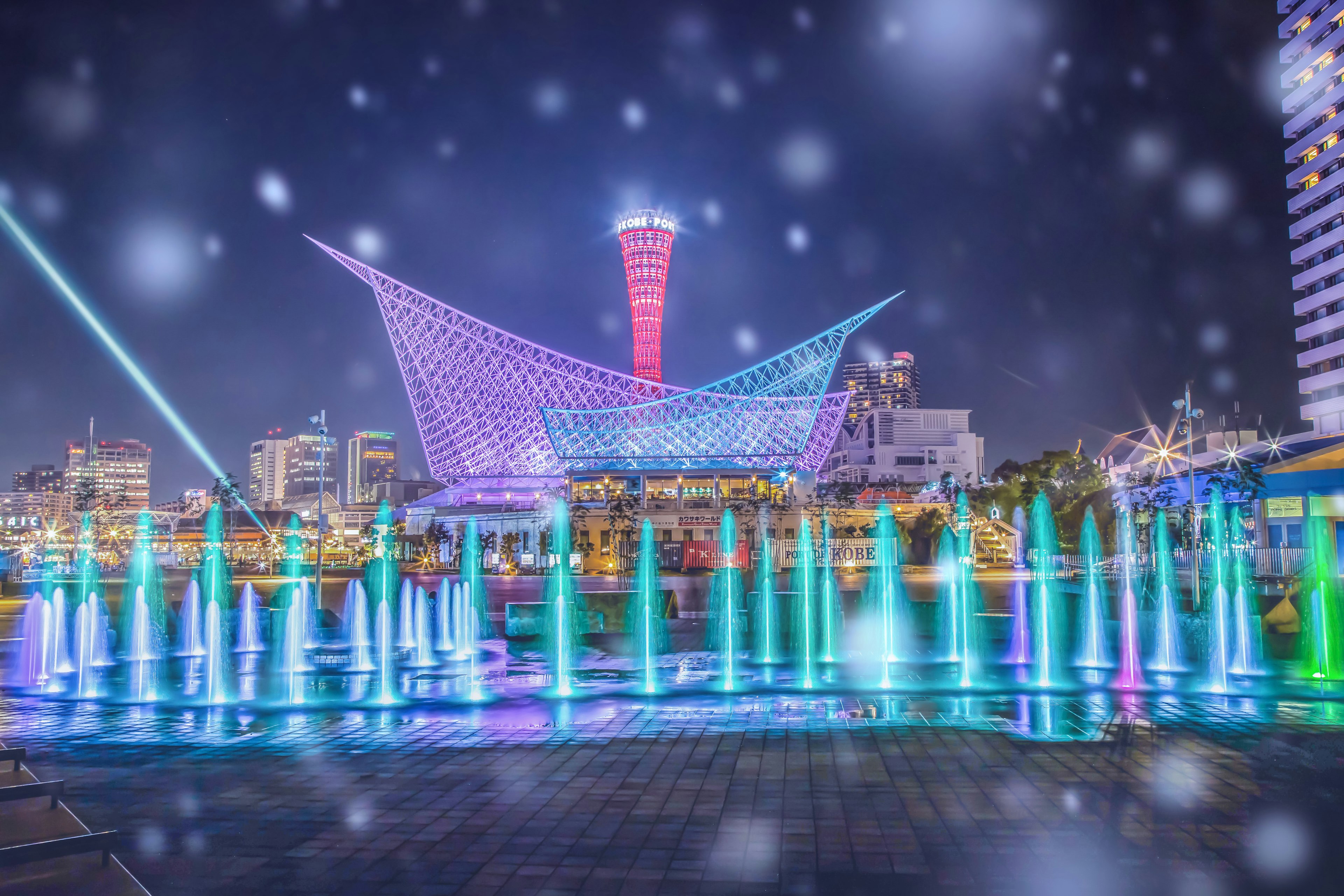 Bunte Brunnen und moderne Architektur bei Nacht in Kobe beleuchtet