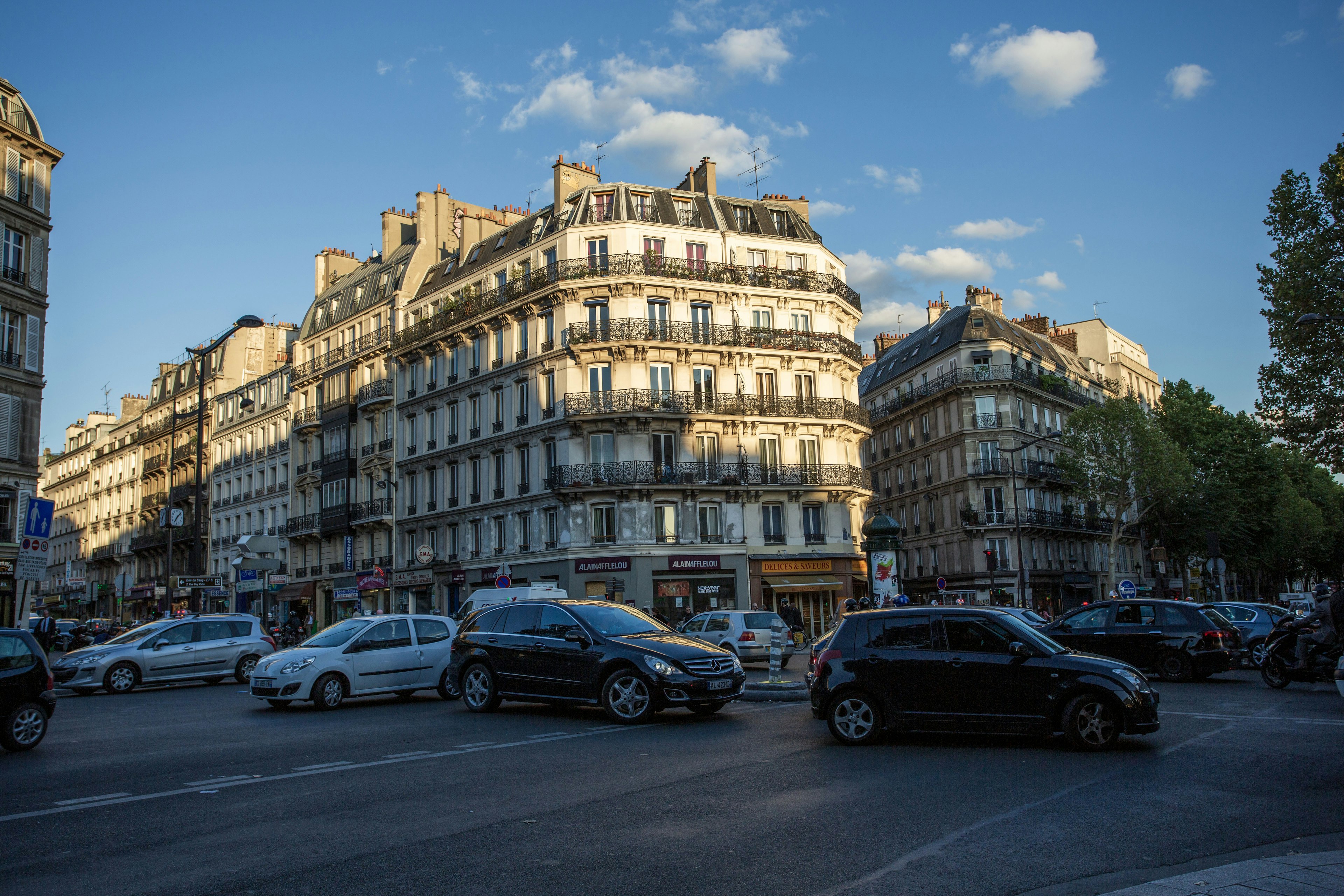 Escena callejera en París con edificios clásicos y coches