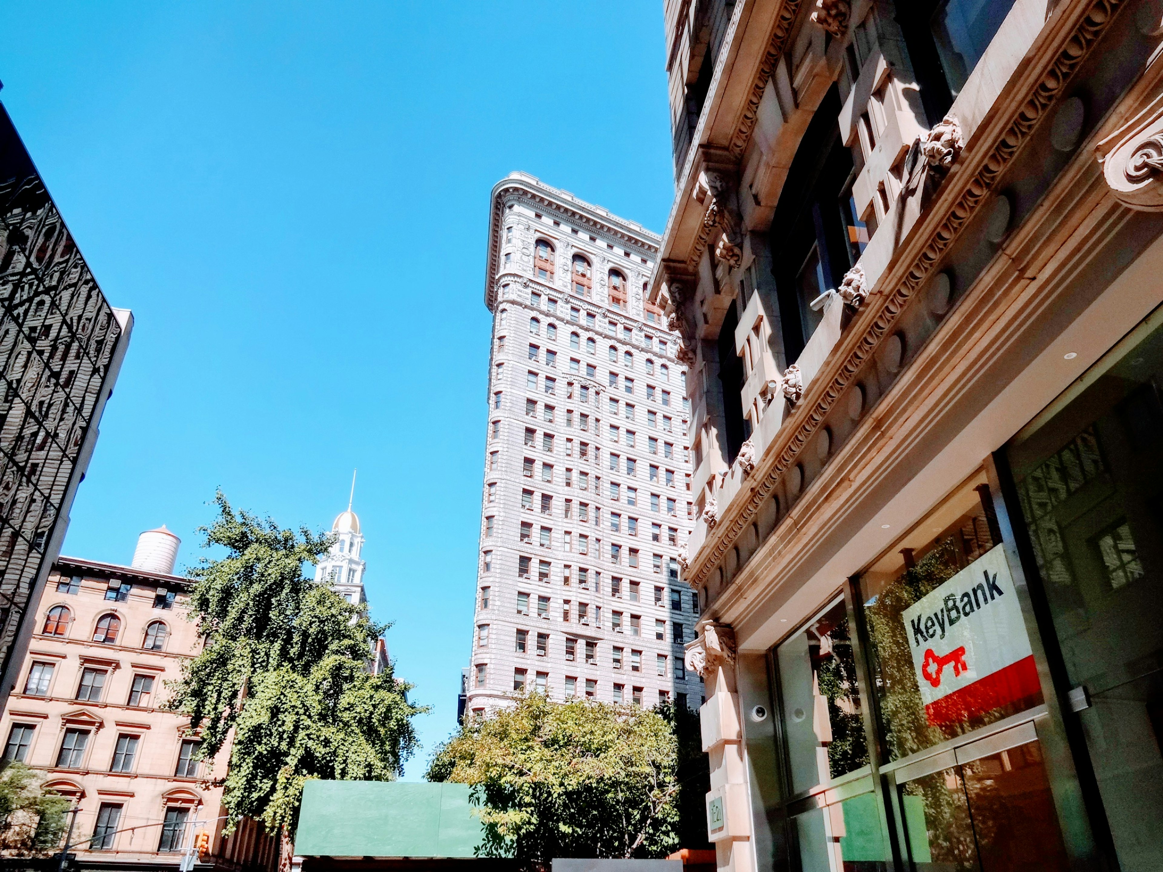 Historic building and modern skyscraper under a clear blue sky